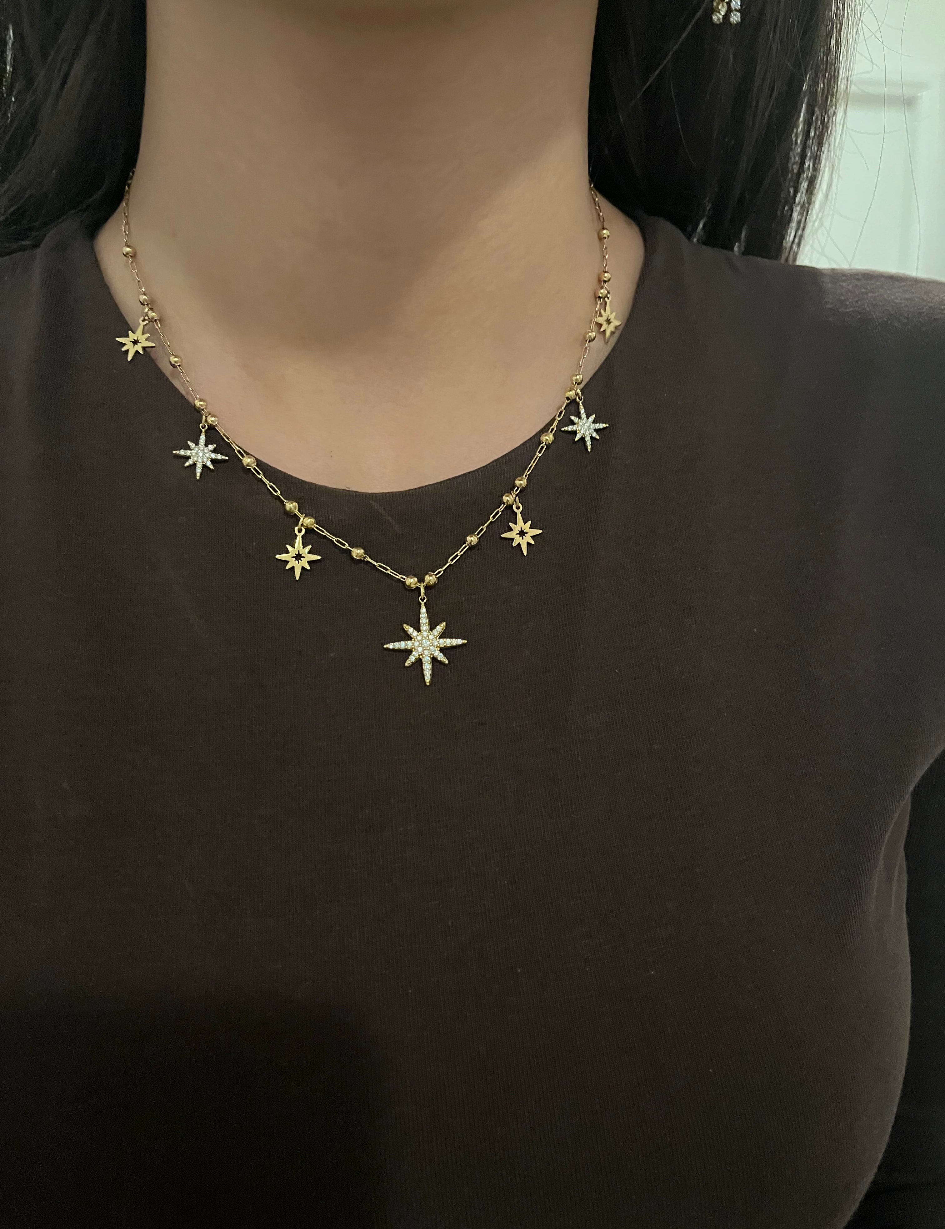 Collier Nuna doré à pendentifs étoiles porté au cou
