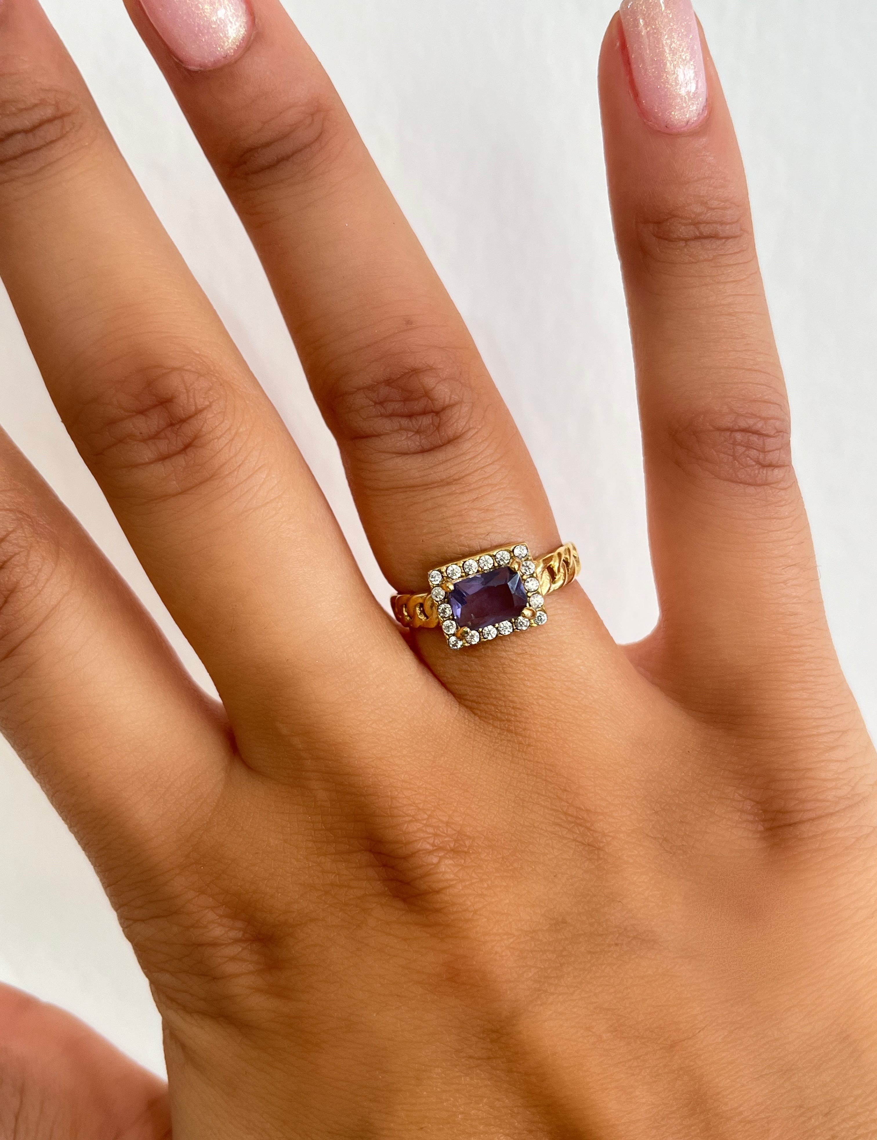 Bague Nora dorée à pierre rectangulaire violette entourée de strass, portée au doigt - Ordiajade