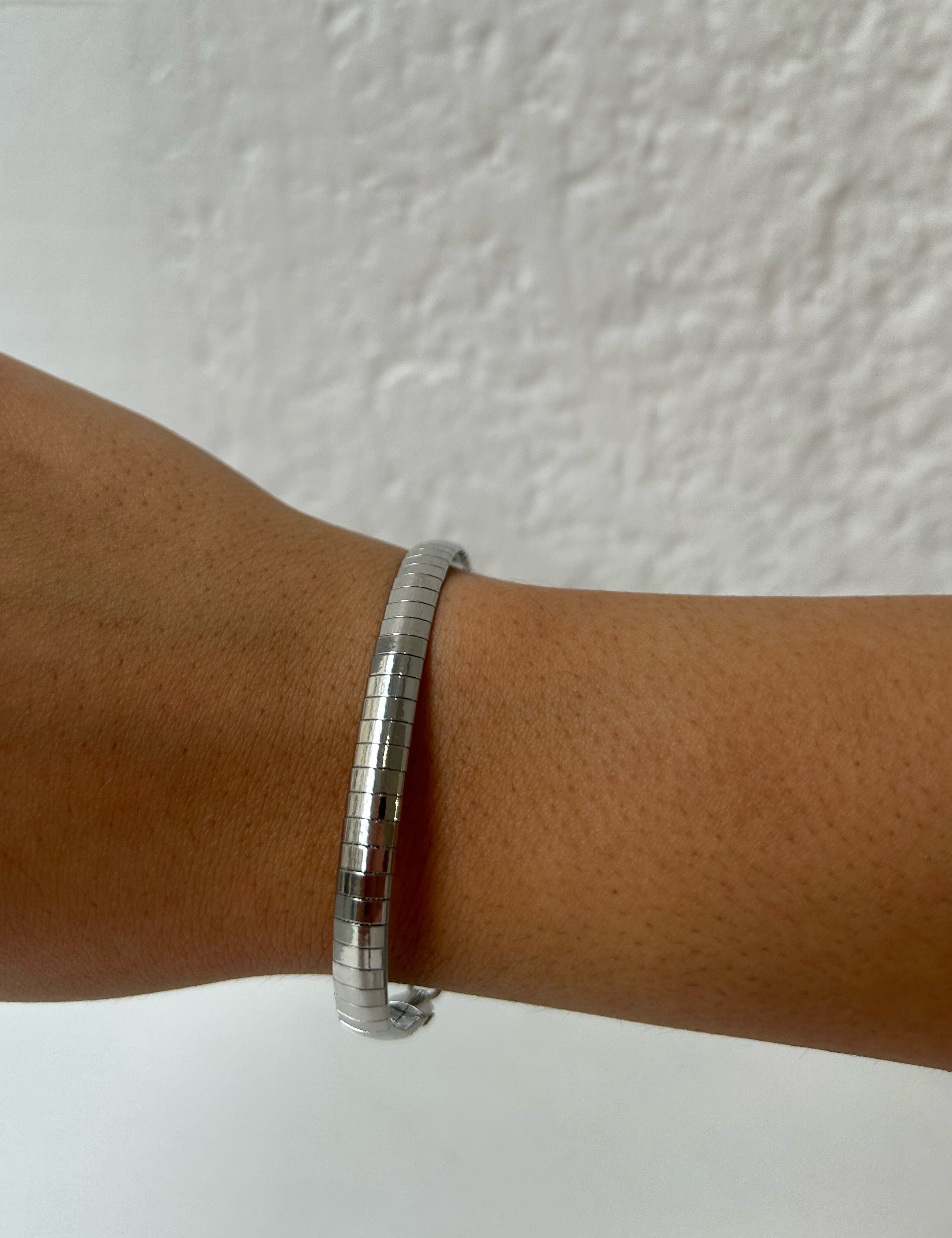 Bracelet Fly argenté souple à petites plaques rectangulaires porté au poignet - Ordiajade