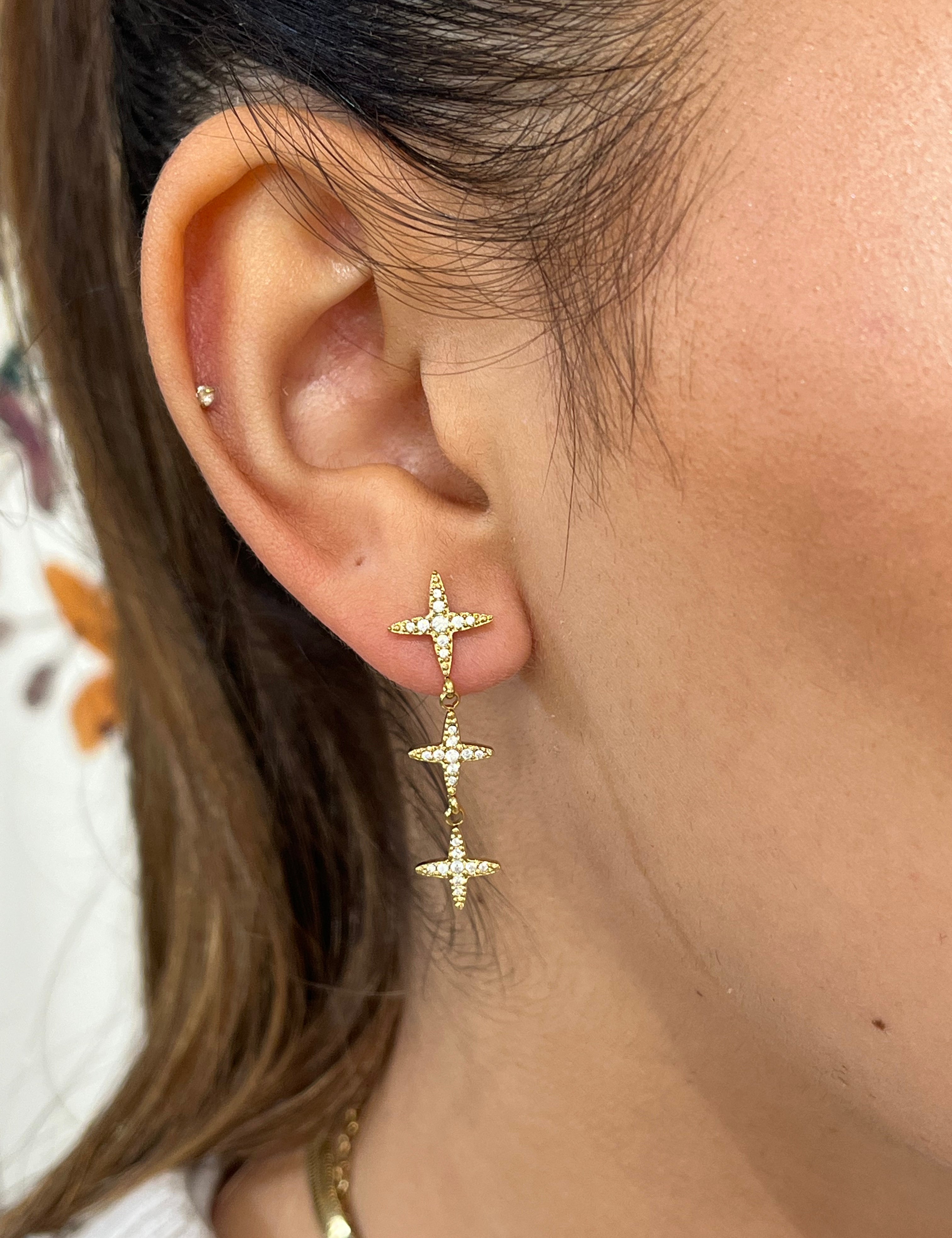 Boucles Hope pendantes à trois petites étoiles dorées, portées à l'oreille - Ordiajade