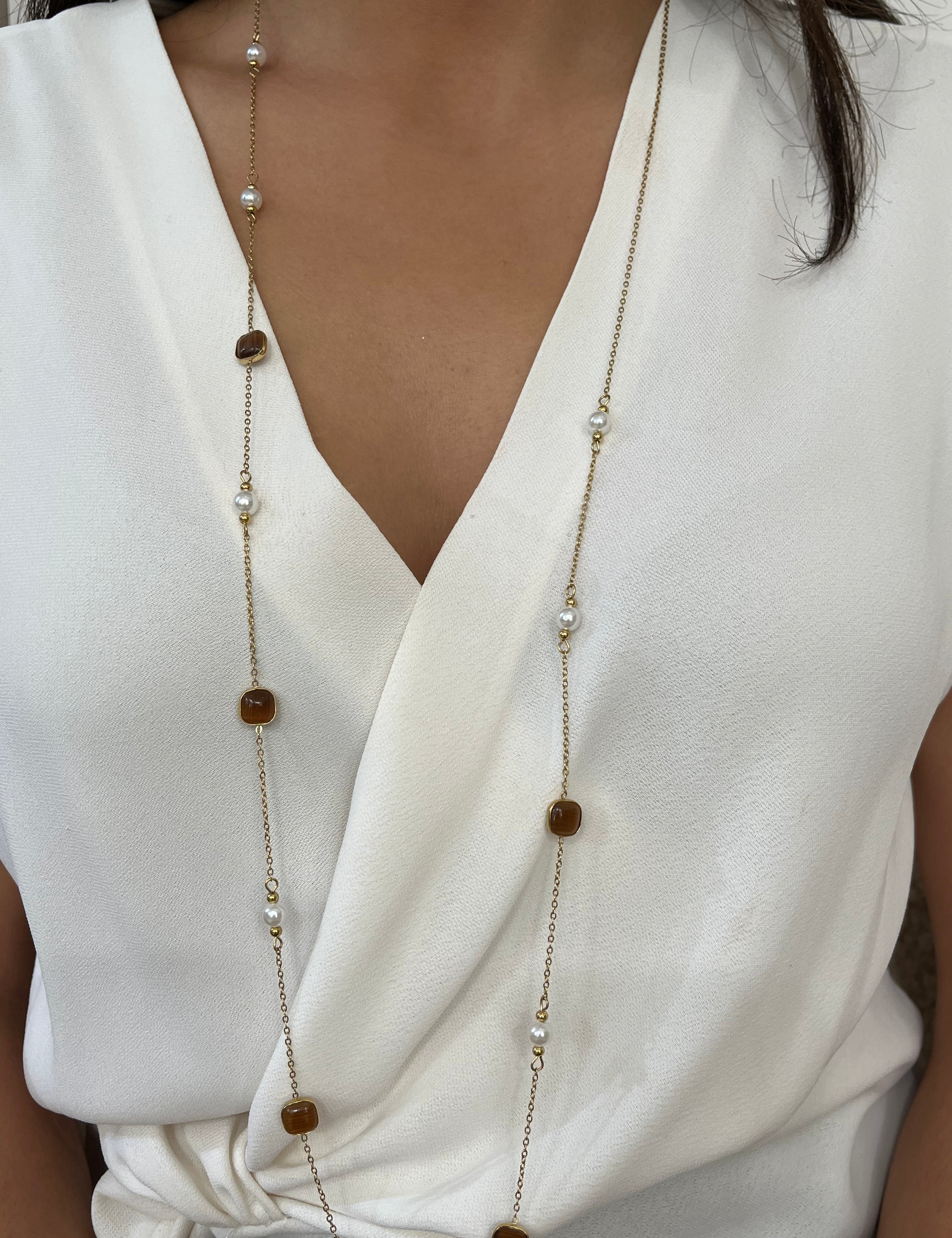 Sautoir long Lolita doré à perles et pierres marron porté sur un chemisier blanc - Ordiajade