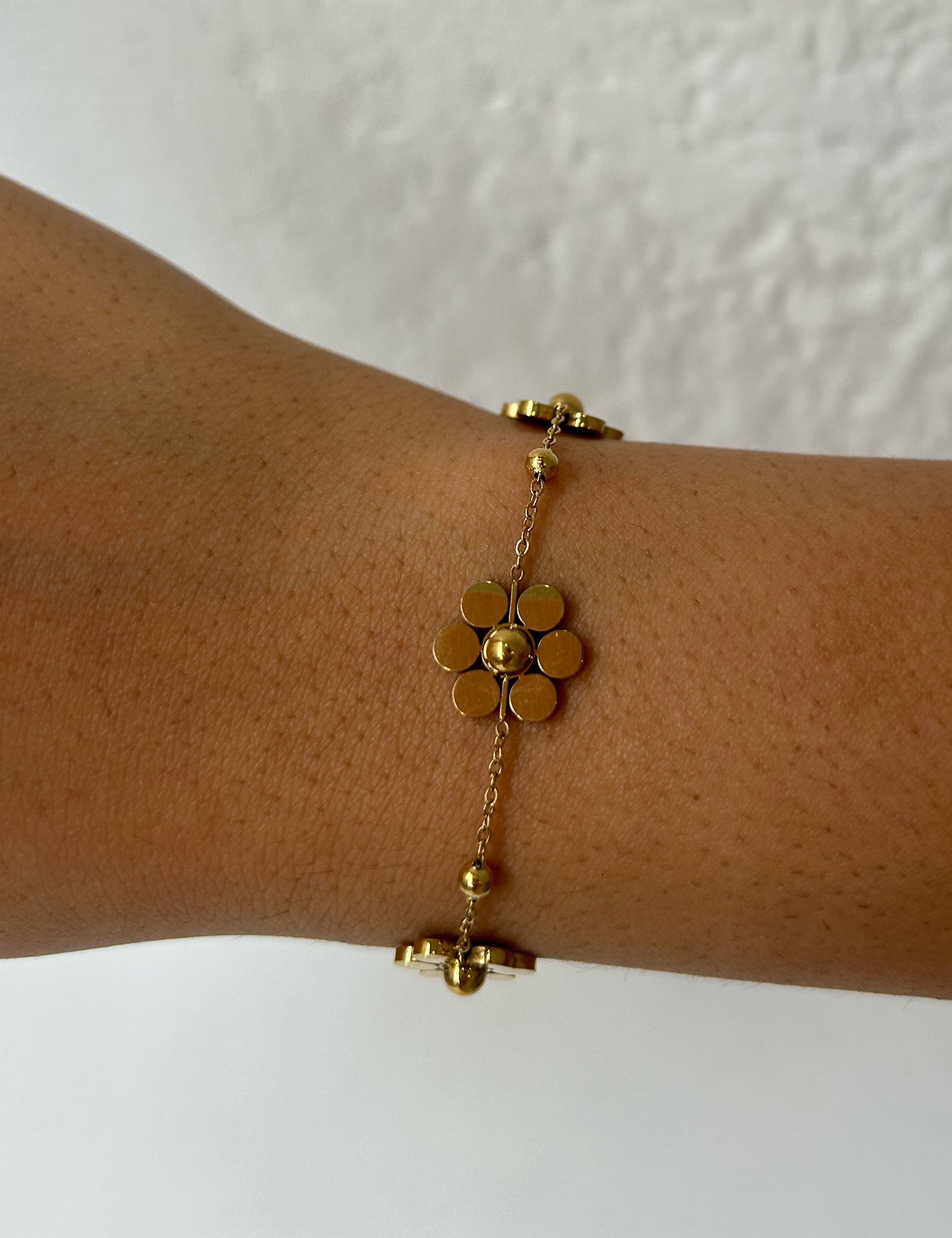 Bracelet Fleurs doré à petites fleurs stylisées porté au poignet - Ordiajade