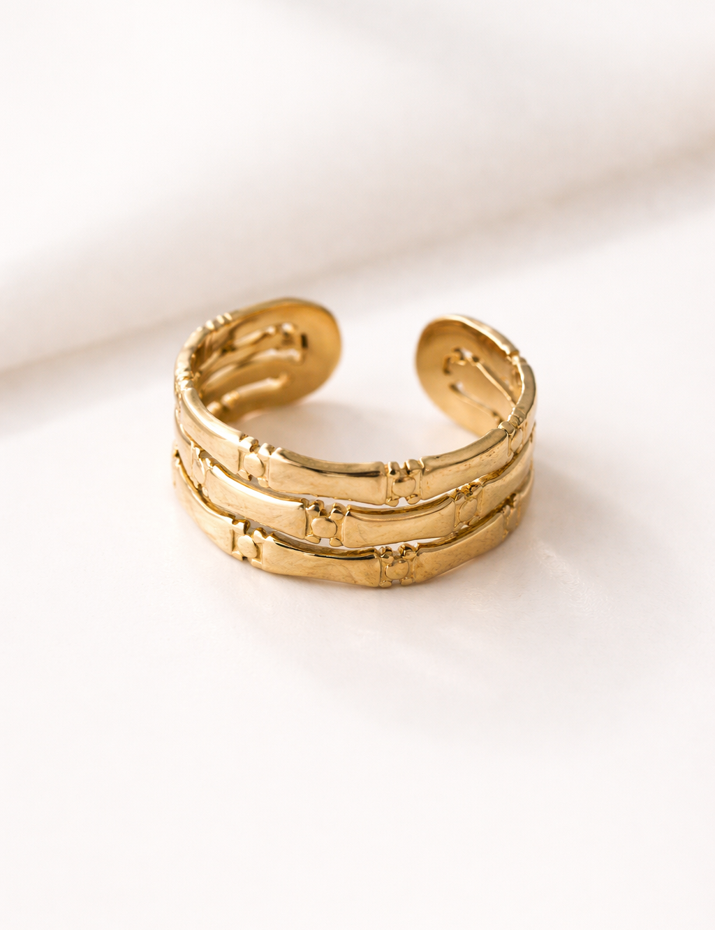 Bague Reflet dorée à trois anneaux texturés reliés, sur fond clair - Ordiajade
