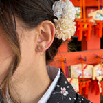 Boucles Hacu double trou dorées : étoile sertie reliée par une chaîne à une petite puce, portées à l'oreille au Japon - Ordiajade