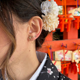 Boucles Hacu double trou dorées : étoile sertie reliée par une chaîne à une petite puce, portées à l'oreille au Japon - Ordiajade