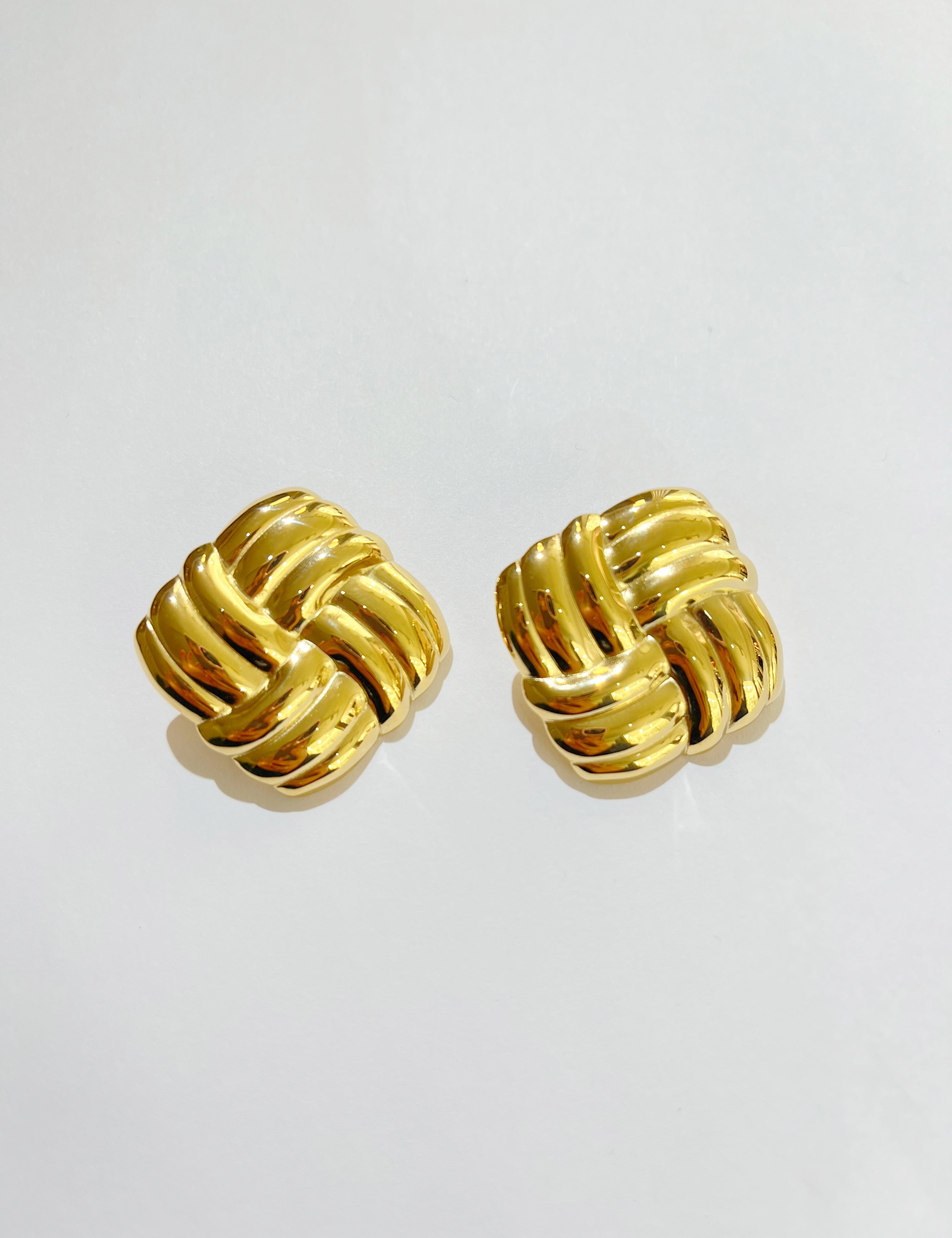 Boucles d'oreilles Kamila dorées en forme de nœud carré, sur fond gris - Ordiajade