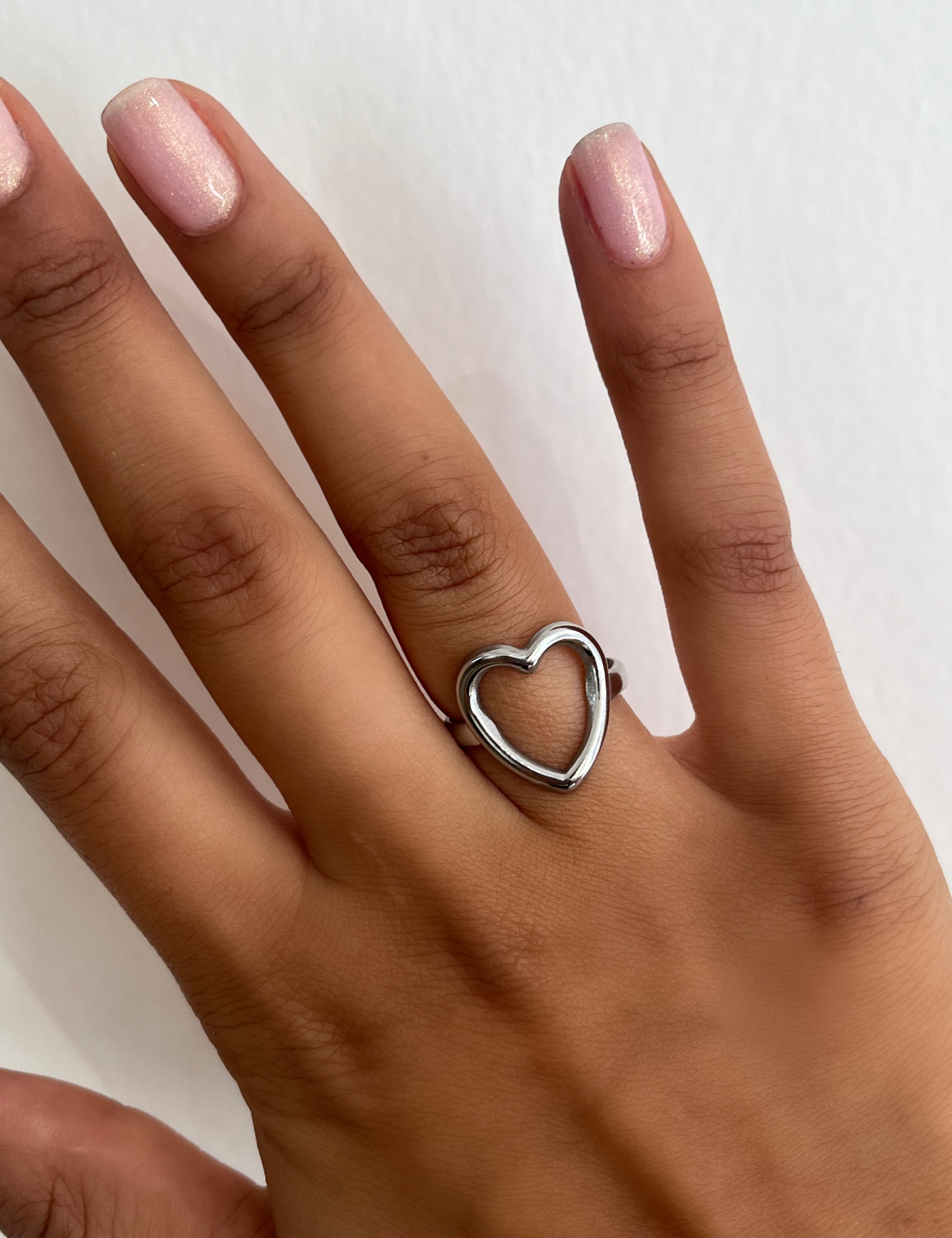 Bague Amore argentée surmontée d'un cœur évidé, portée au doigt - Ordiajade