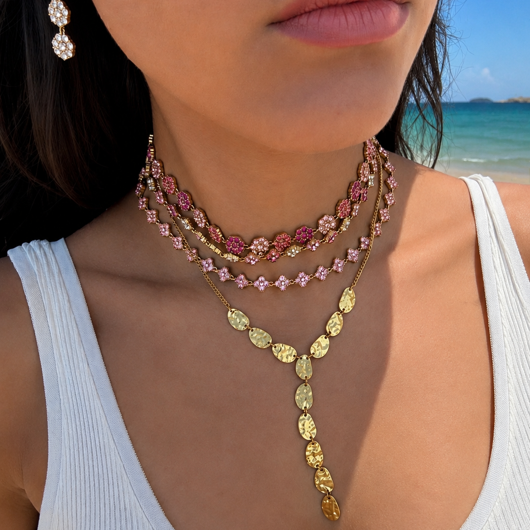 Accumulation de colliers dorés avec le collier Coraline à trèfles roses portée à la plage - Ordiajade