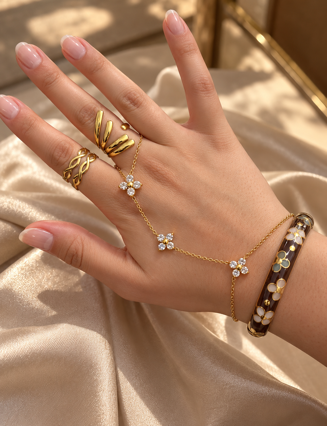 Bracelet jonc Splendeur porté au poignet avec une chaîne de main et des bagues dorées - Ordiajade