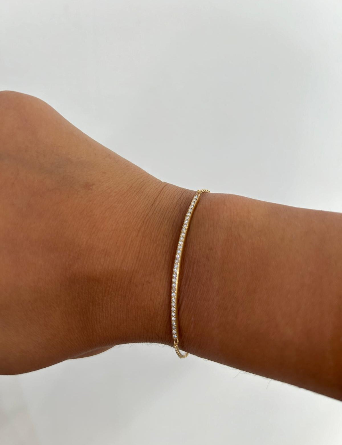 Bracelet Scintillant doré fin serti de petites pierres porté au poignet - Ordiajade