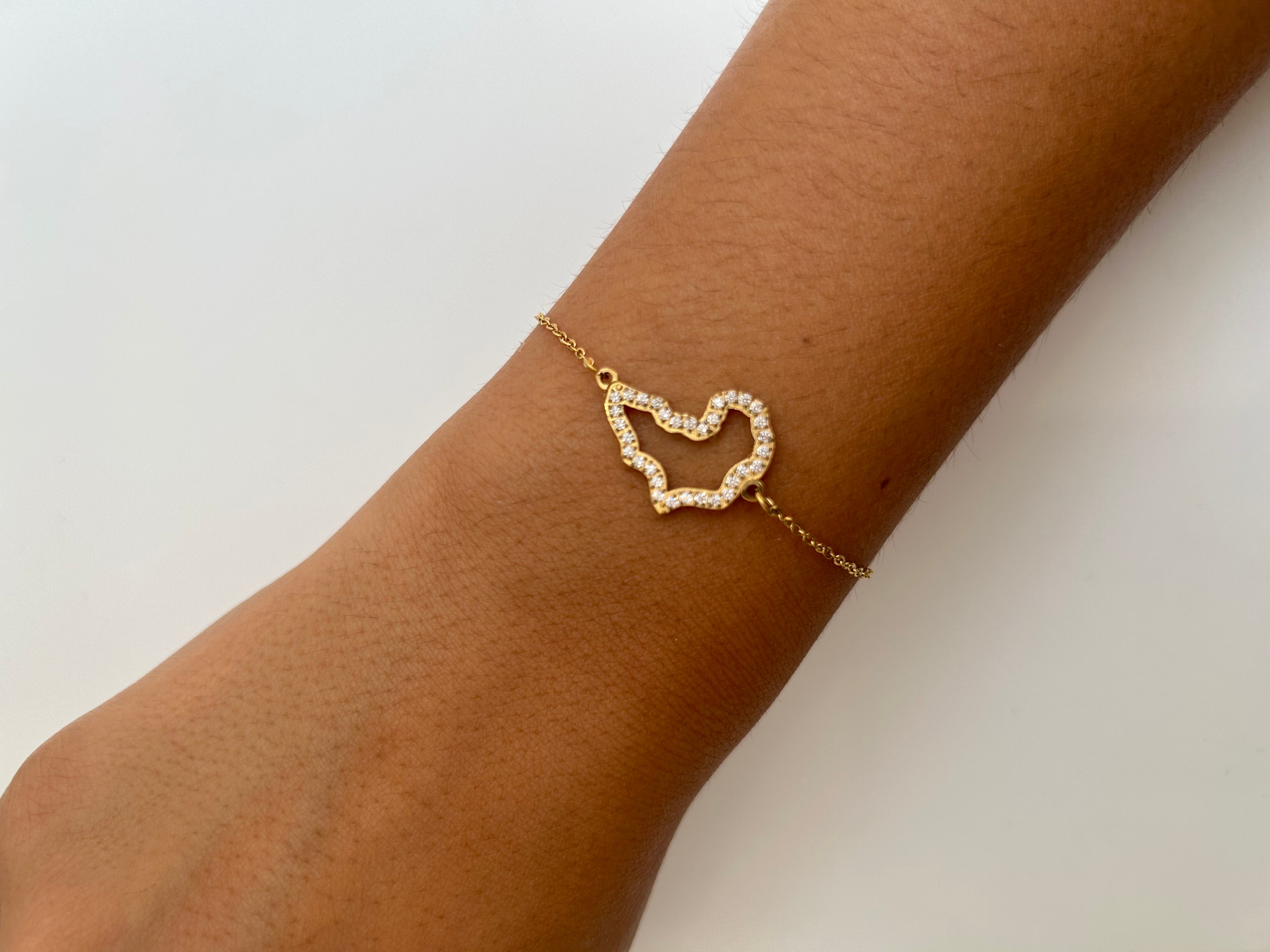 Bracelet Afrique doré à contour du continent africain serti de strass, porté au poignet - Ordiajade