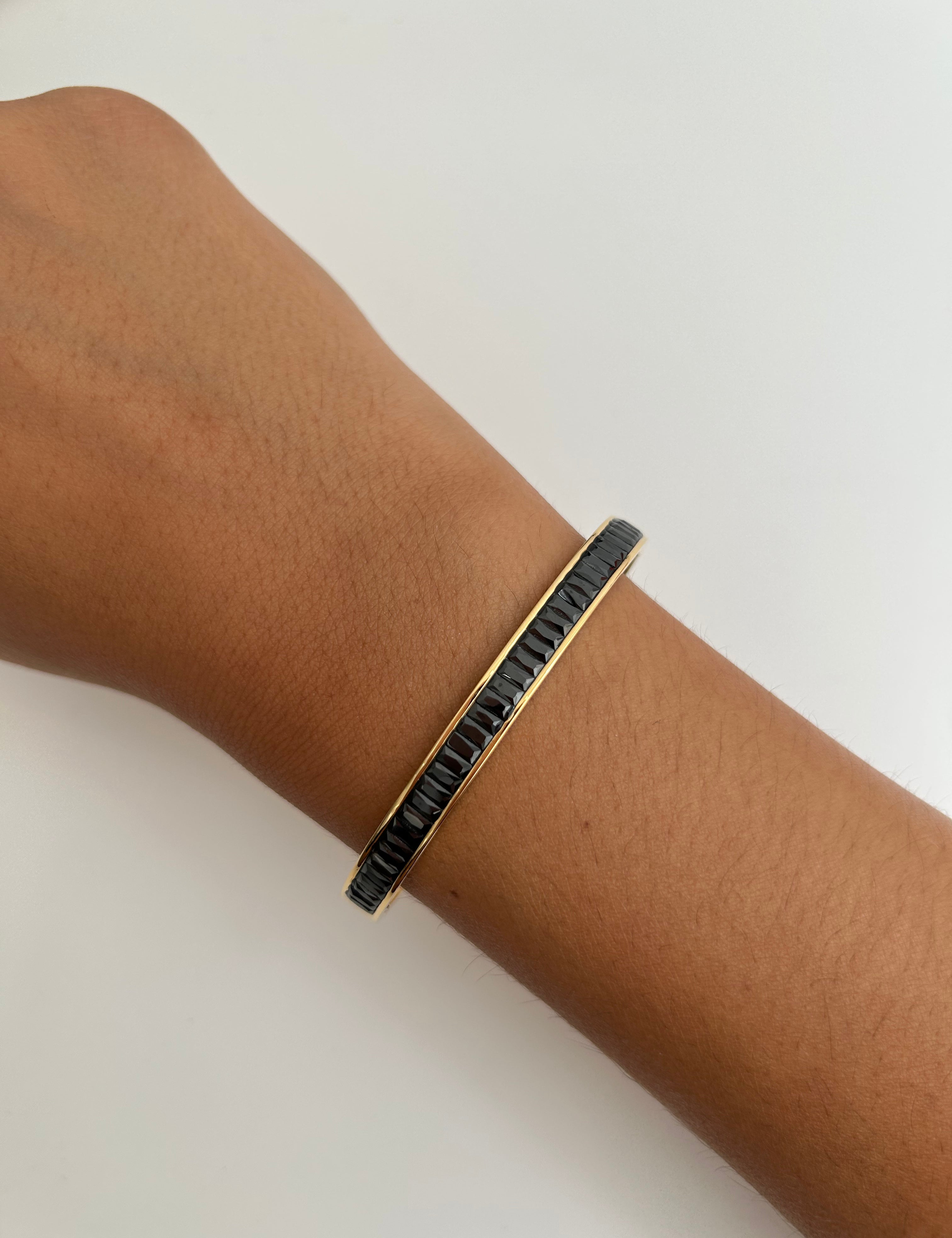 Jonc Dark doré ovale serti d'une ligne de strass noirs, porté au poignet - Ordiajade