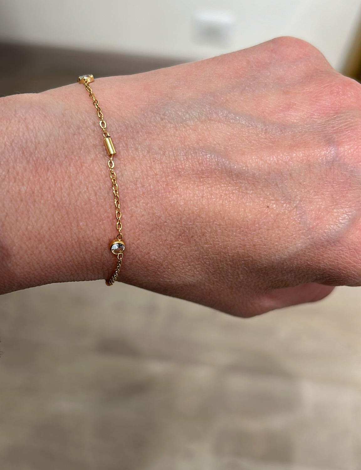 Bracelet Cyclone doré à petits tubes et pierre porté au poignet - Ordiajade