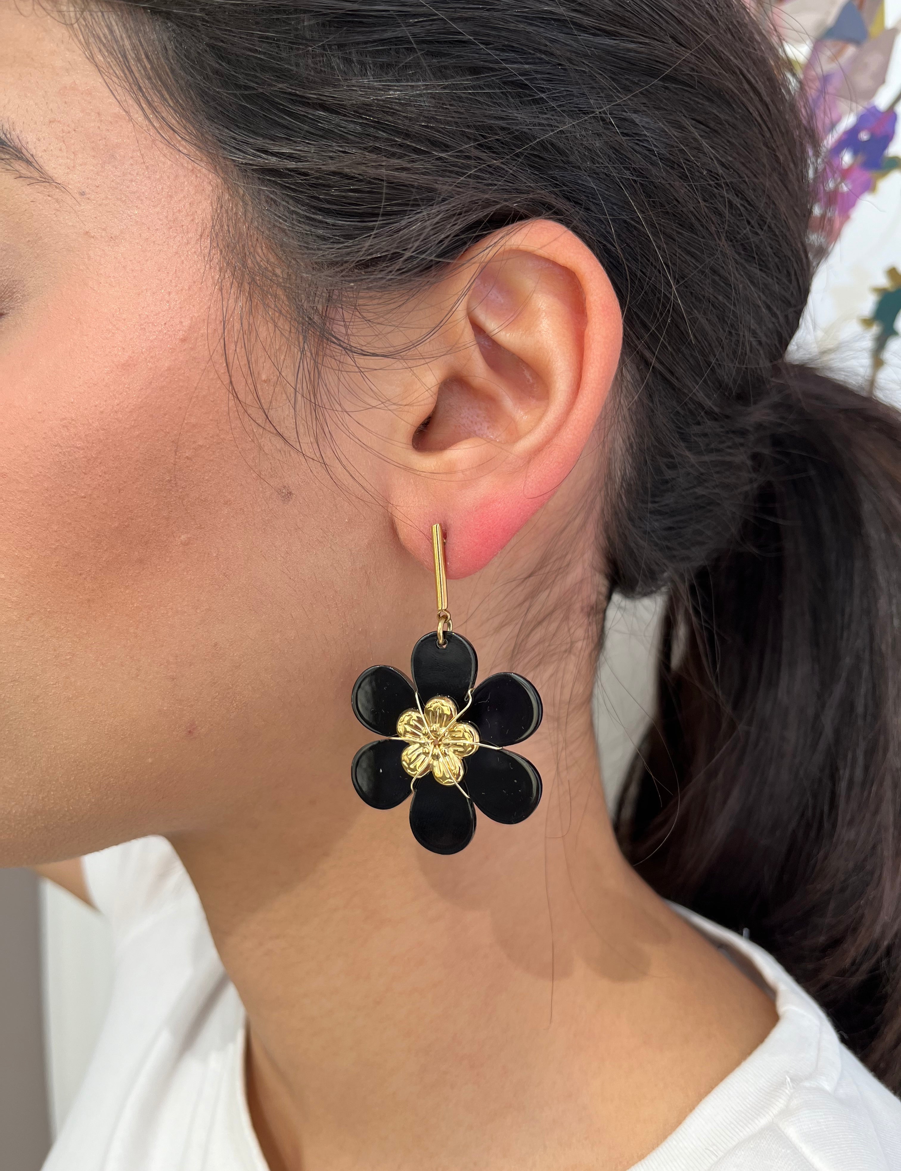 Boucles Hawaï pendantes, fleur noire au cœur doré, portées à l'oreille - Ordiajade
