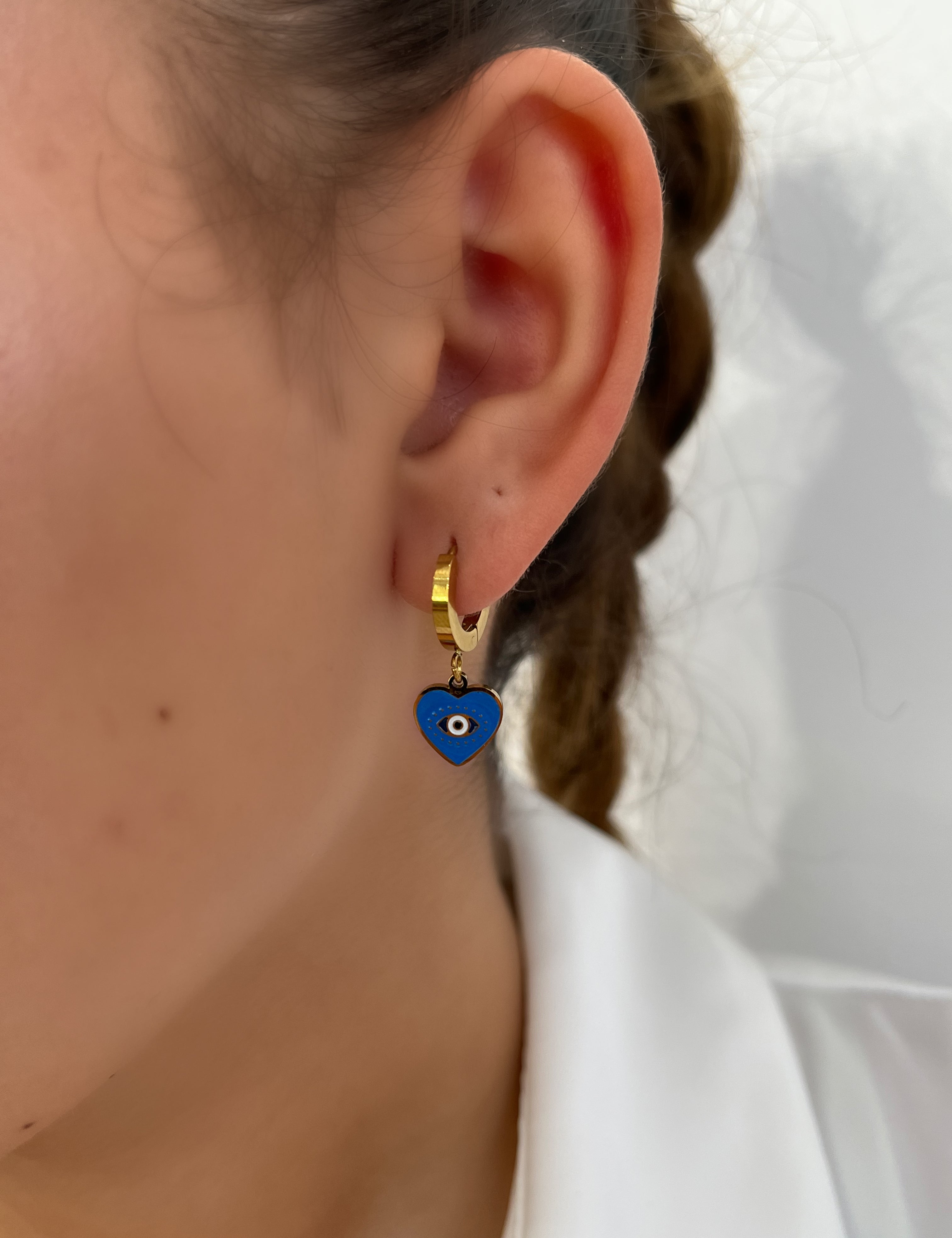 Boucles Bleu Eye, créole dorée à cœur bleu orné d'un œil, portée à l'oreille - Ordiajade
