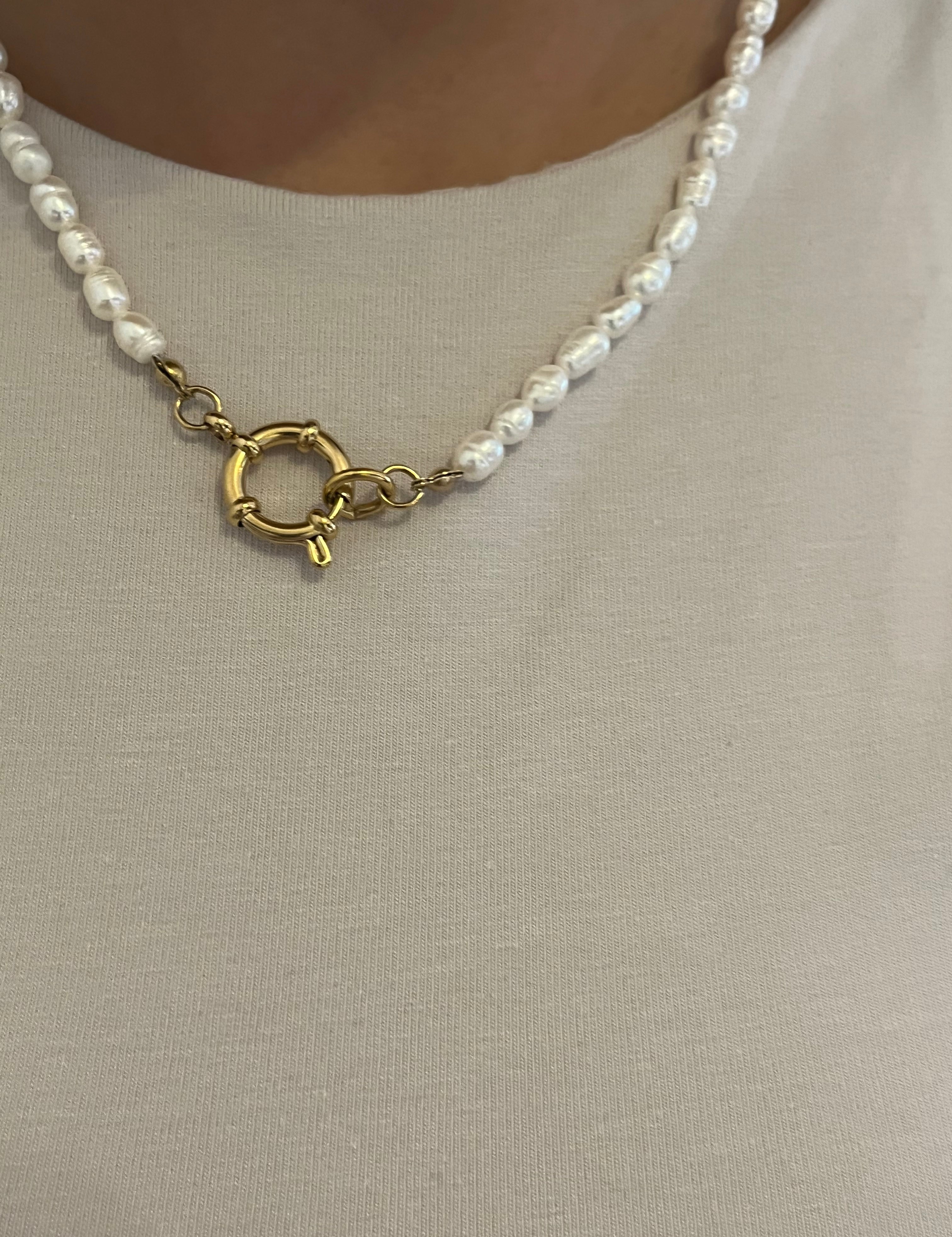 Collier de perles d'eau douce à fermoir rond doré porté sur un haut beige - Ordiajade