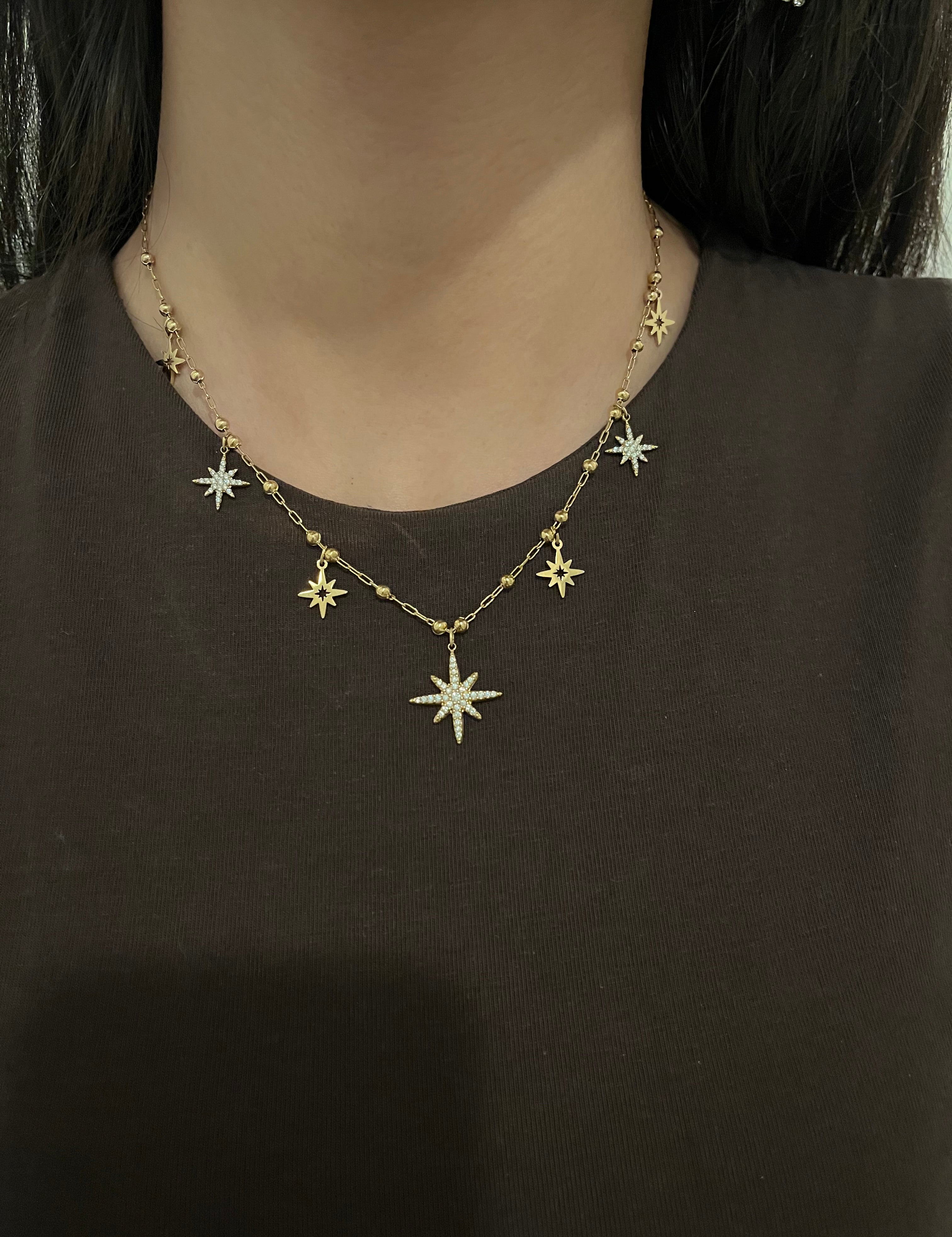 Collier Nuna doré à petites étoiles serties de strass porté avec un haut marron - Ordiajade