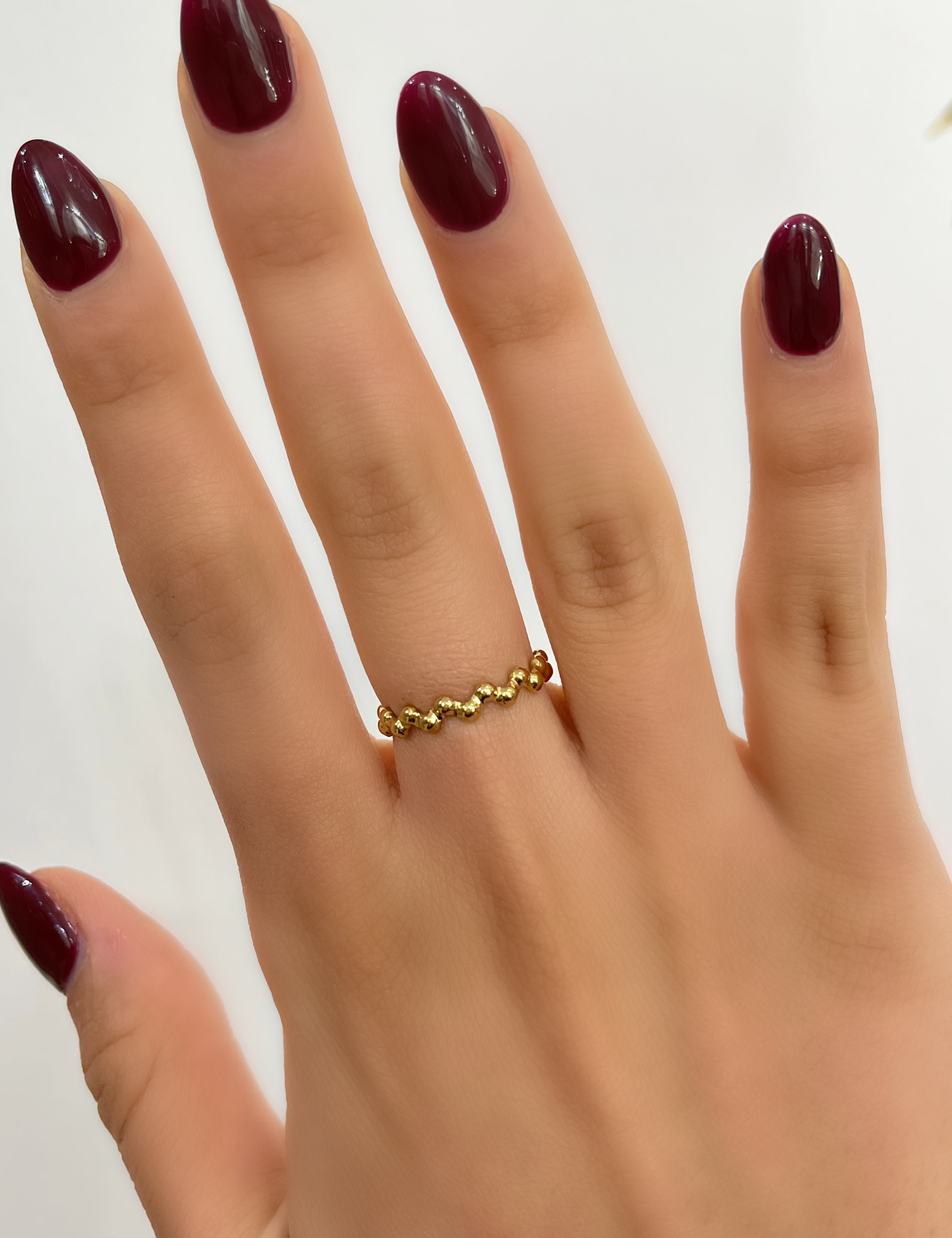 Bague Lory dorée fine et ouverte en petites perles dorées, portée au doigt - Ordiajade