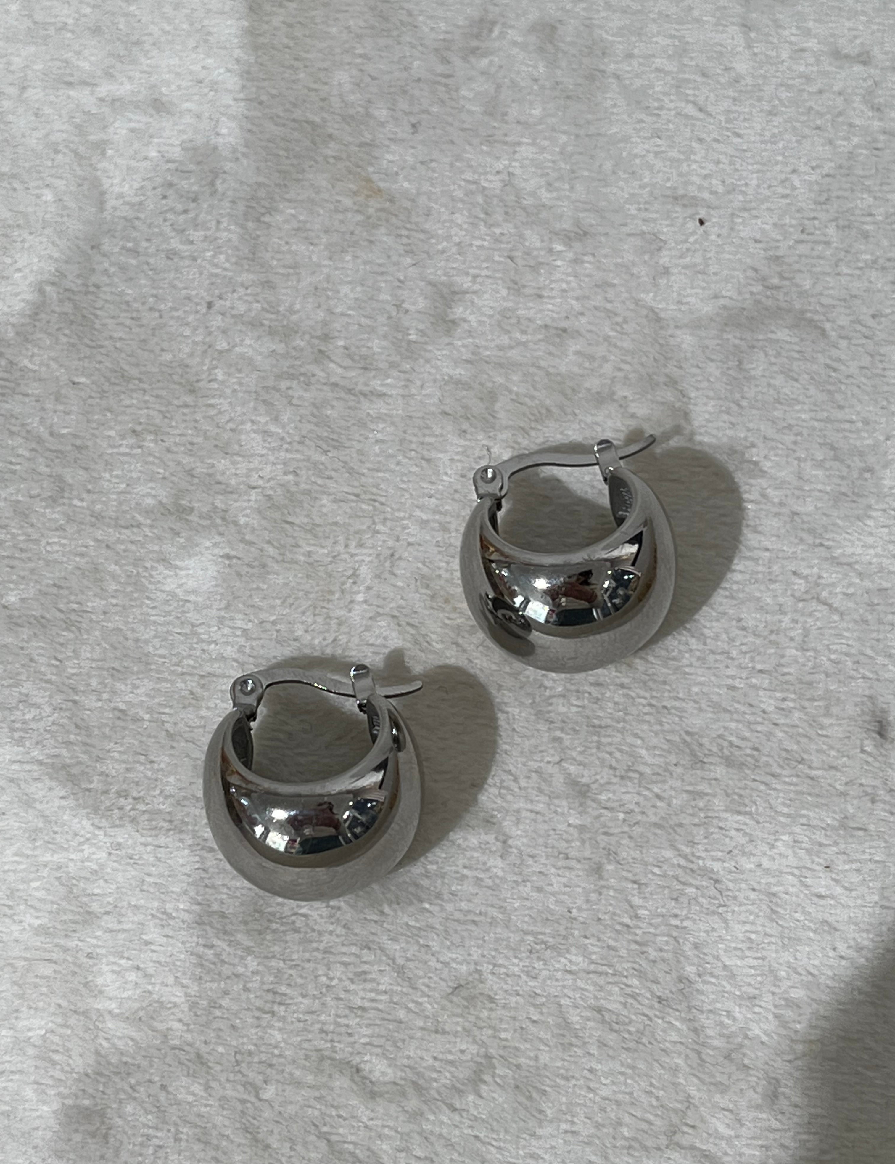 Boucles Héléna argentées en forme de boule bombée, sur fond gris - Ordiajade