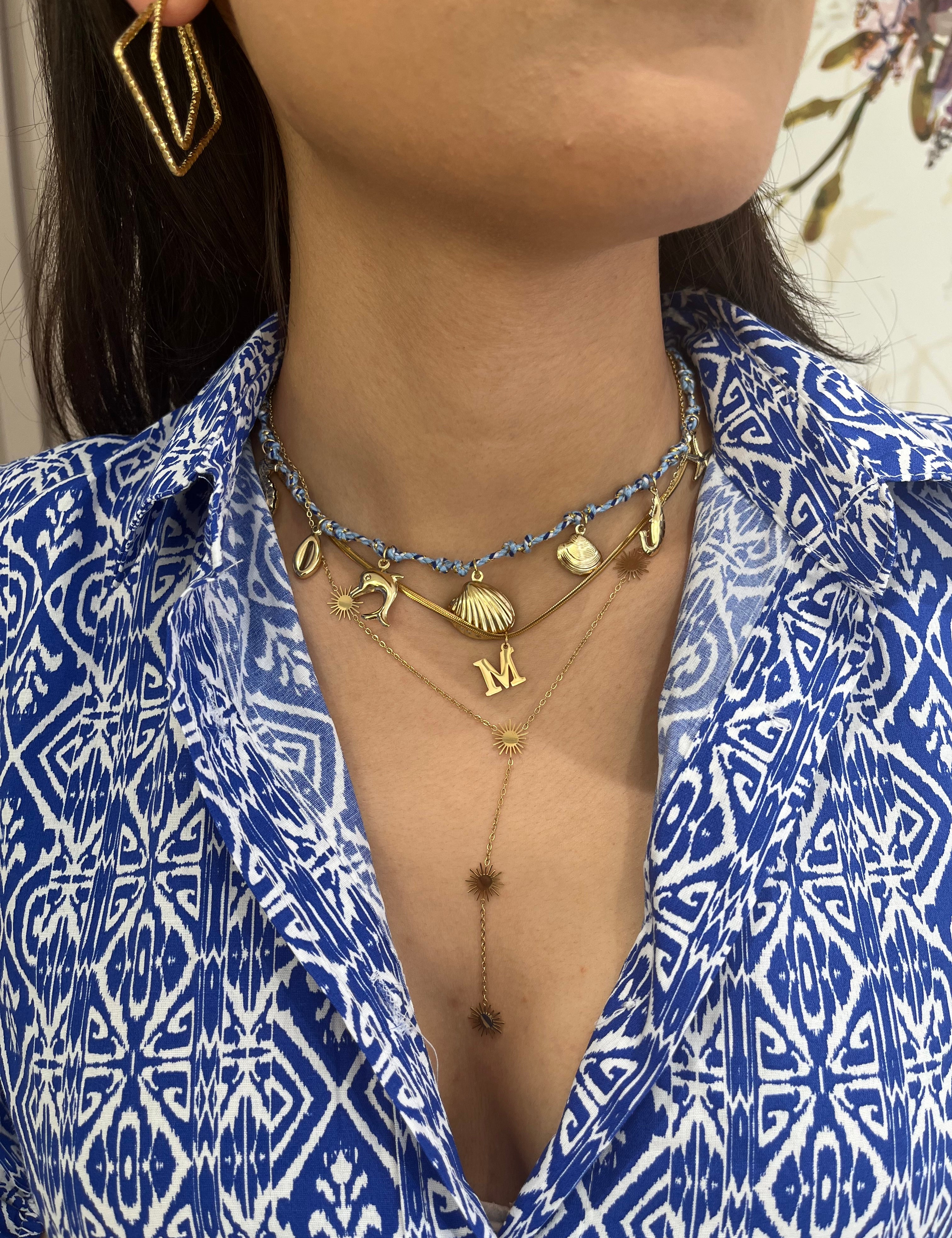 Collier Dangerous bleu porté avec des colliers dorés et une chemise imprimée - Ordiajade