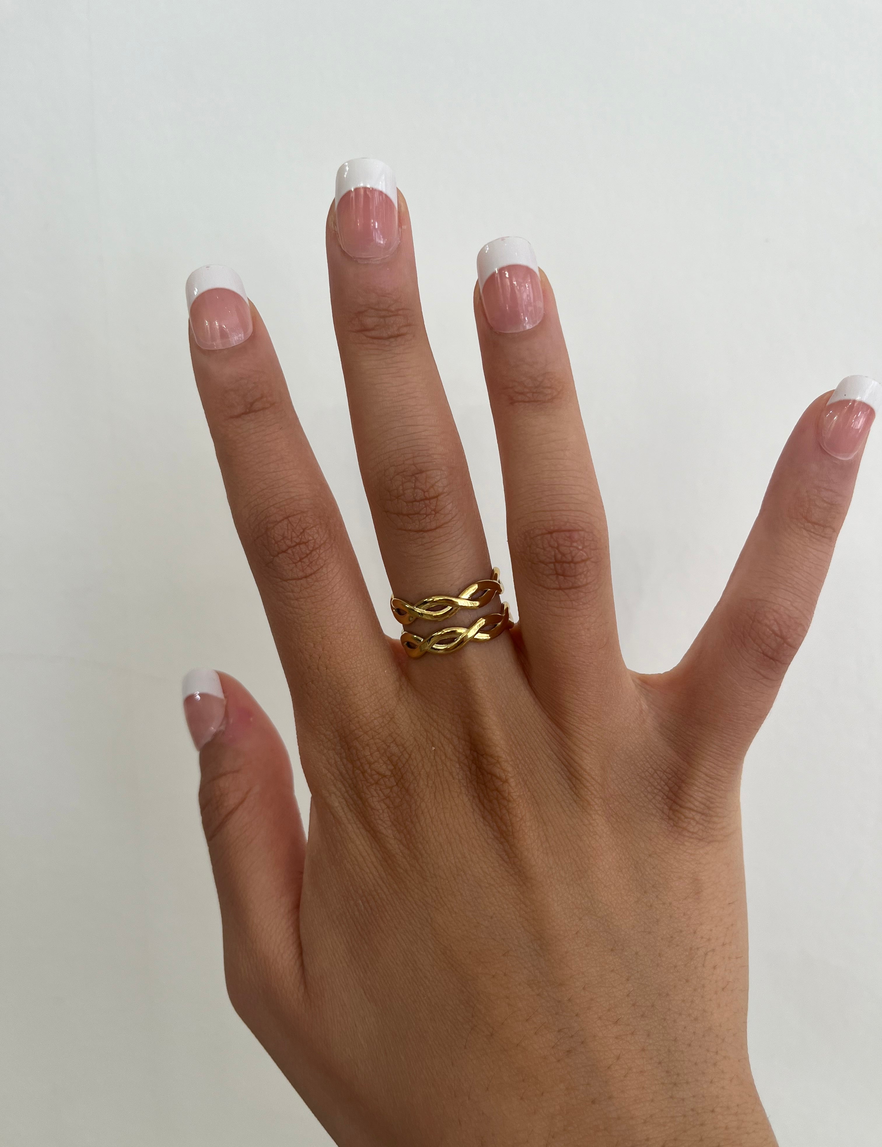 Bague Maissa dorée à deux lignes ondulées croisées, portée au doigt - Ordiajade