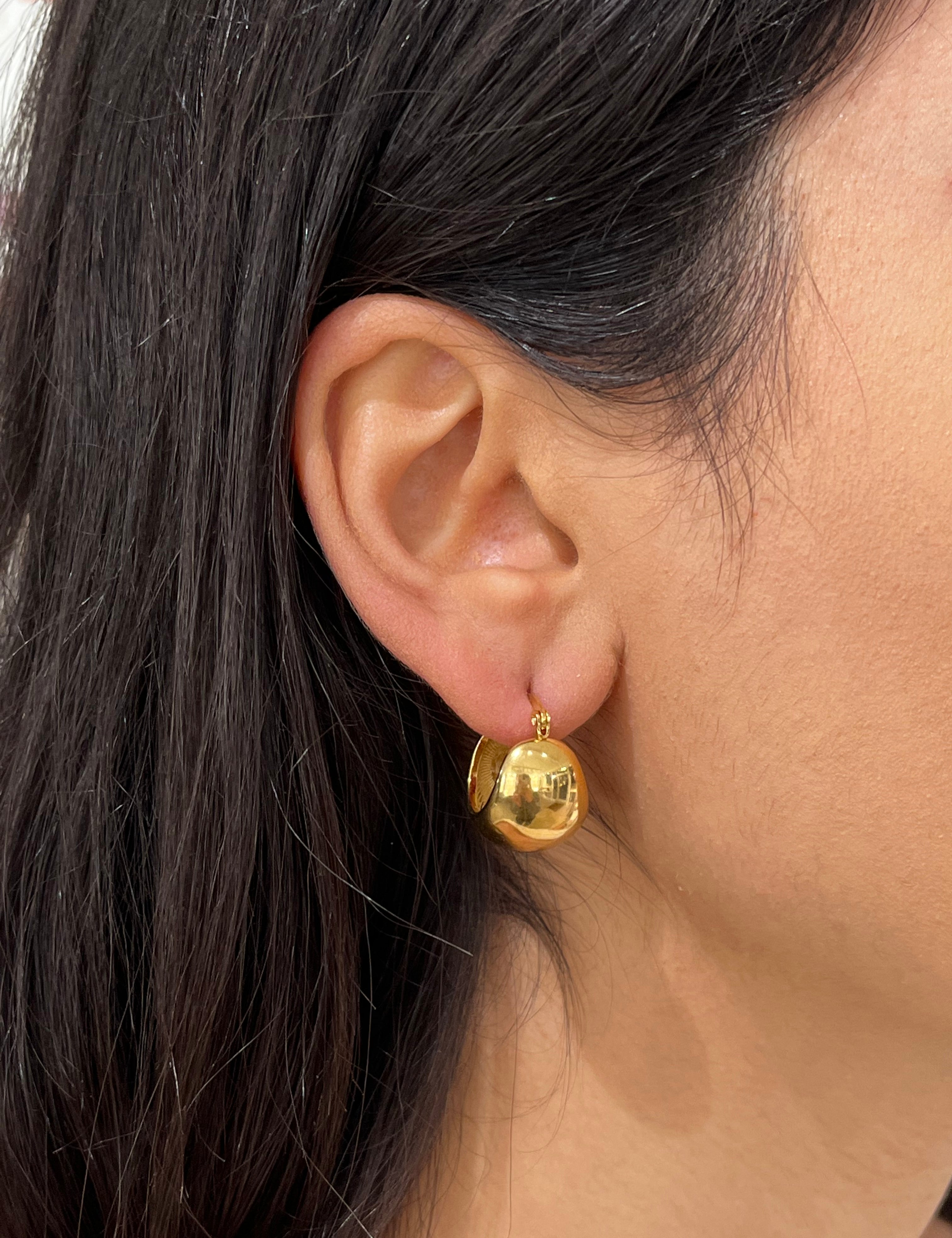 Boucles Héléna dorées en forme de boule bombée portées à l'oreille - Ordiajade