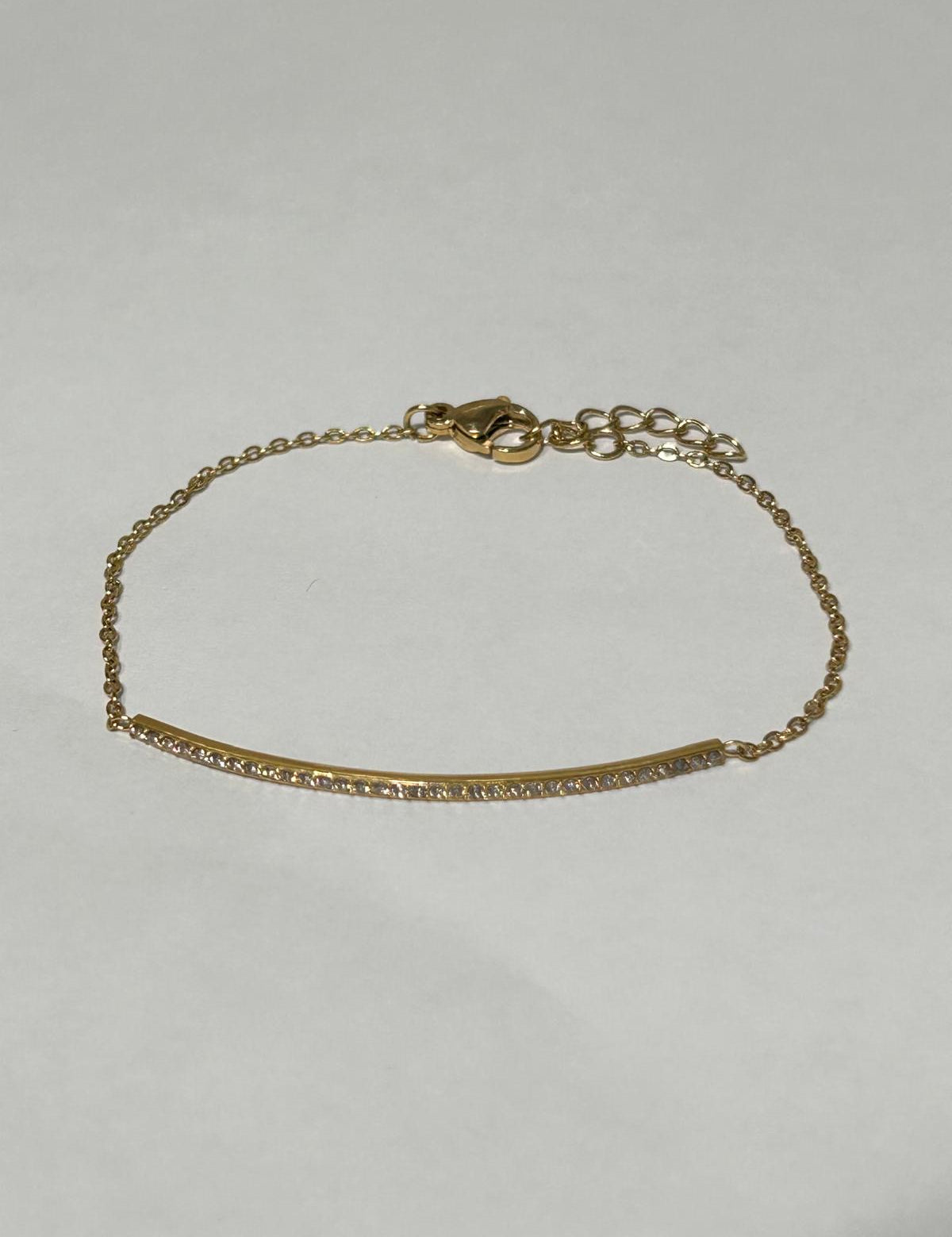Bracelet Scintillant doré à barrette sertie de pierres, sur fond gris - Ordiajade