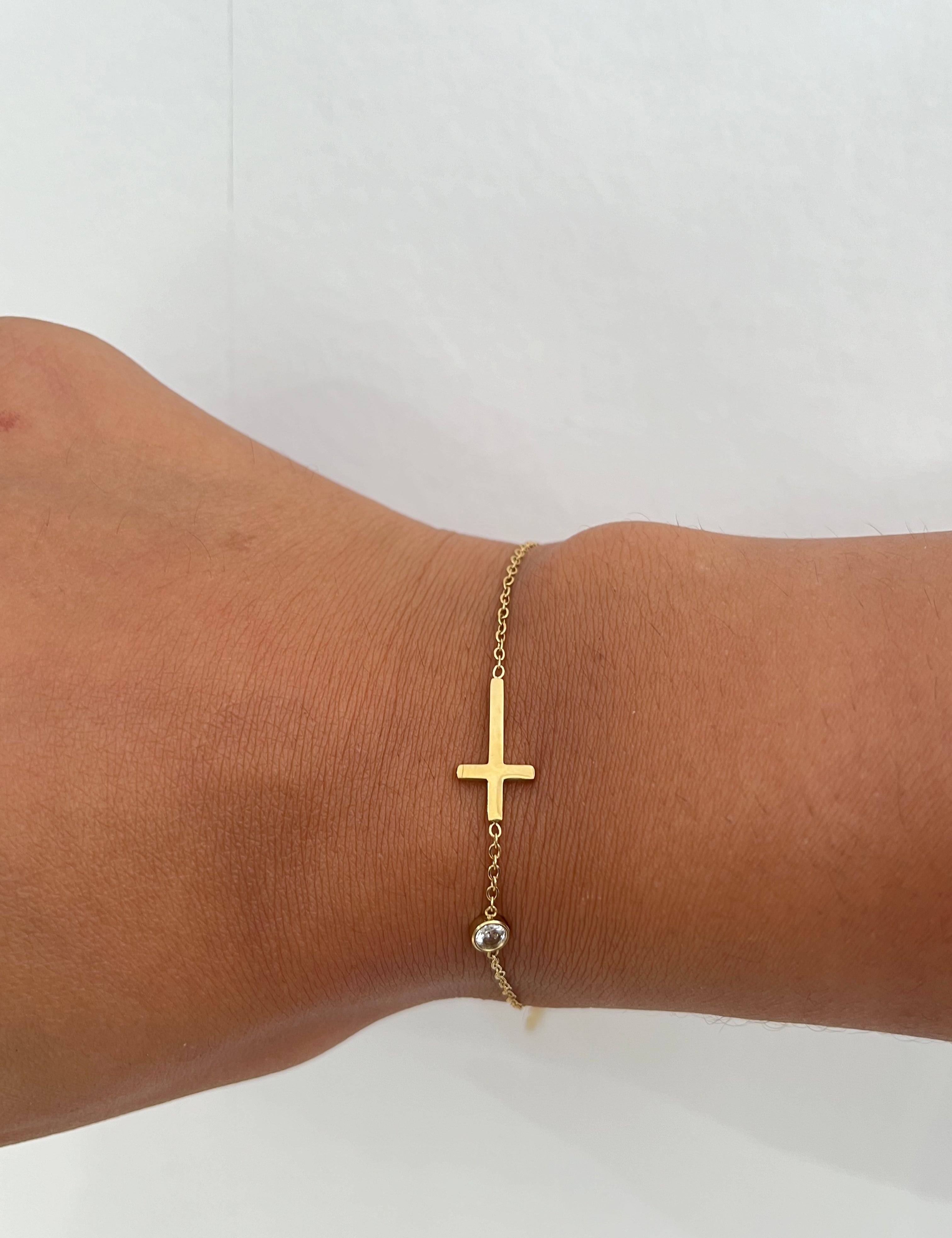 Bracelet Élégant doré à petite croix horizontale porté au poignet - Ordiajade