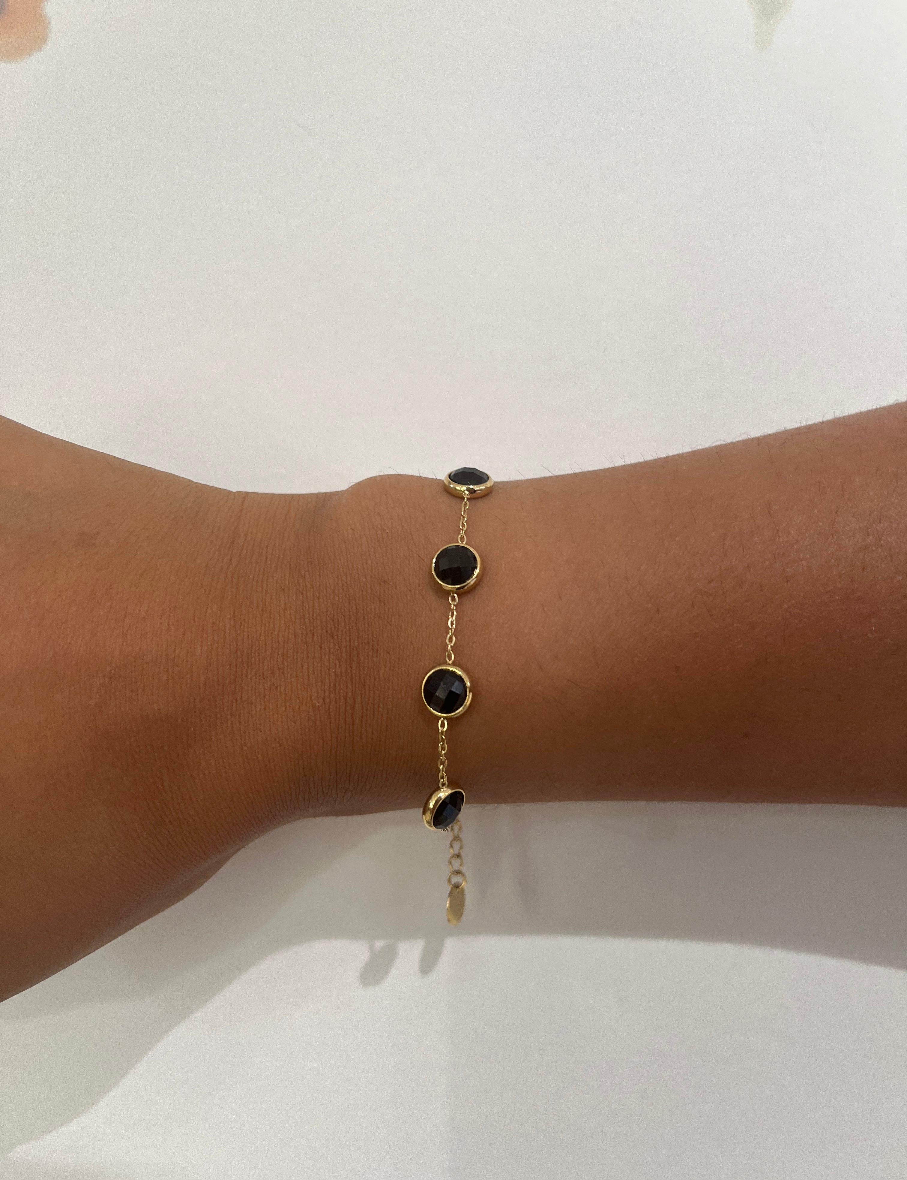 Bracelet Exact doré à pierres rondes noires porté au poignet - Ordiajade