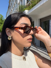 Boucles Mijas dorées en forme de coquillage à perle portées avec des lunettes de soleil - Ordiajade