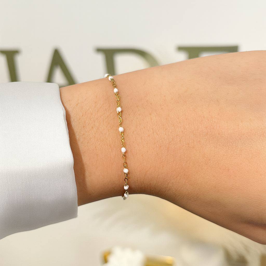 Bracelet fin April doré à perles blanches porté au poignet, vue rapprochée - Ordiajade