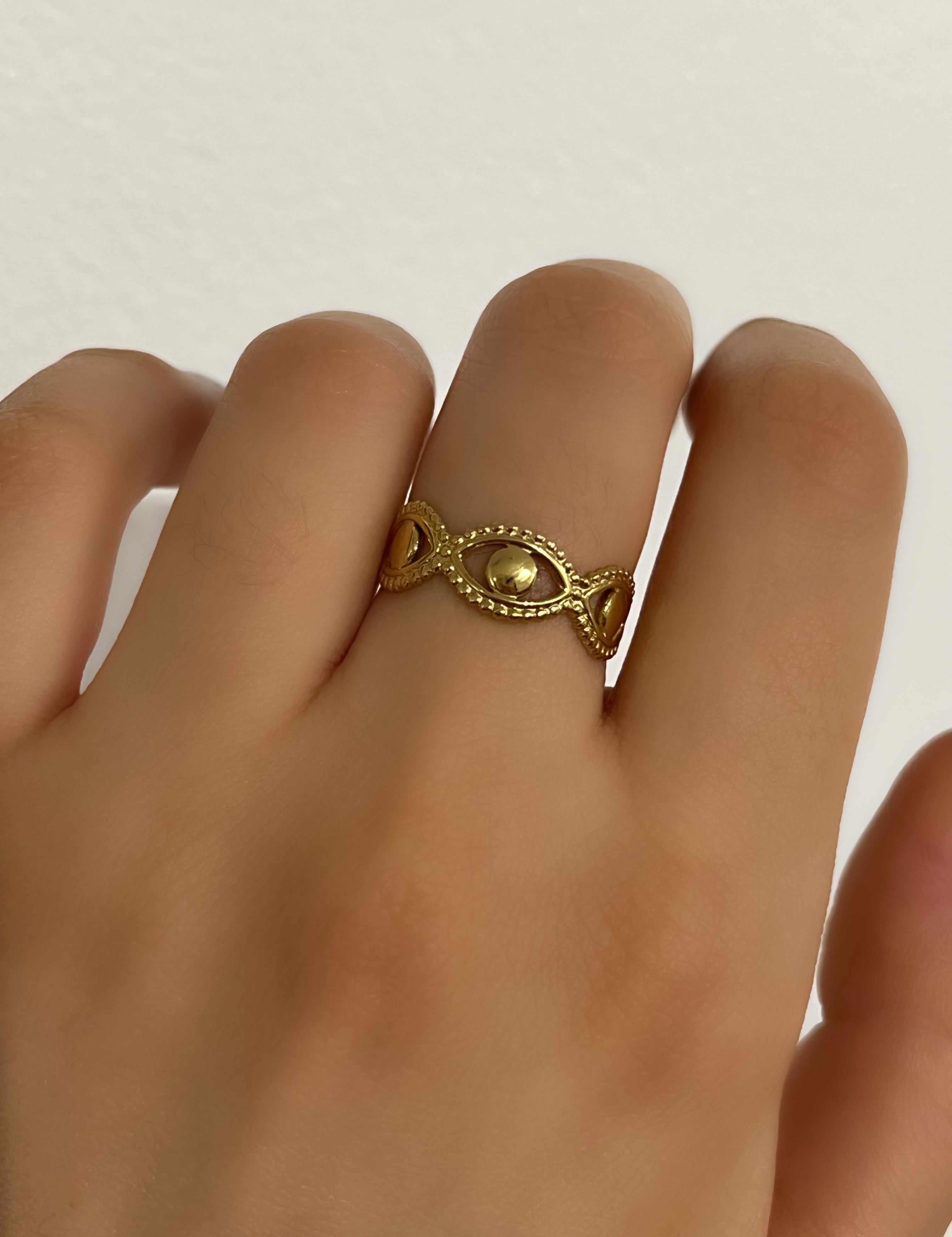 Bague Cori dorée fine à œil stylisé texturé, portée au doigt - Ordiajade