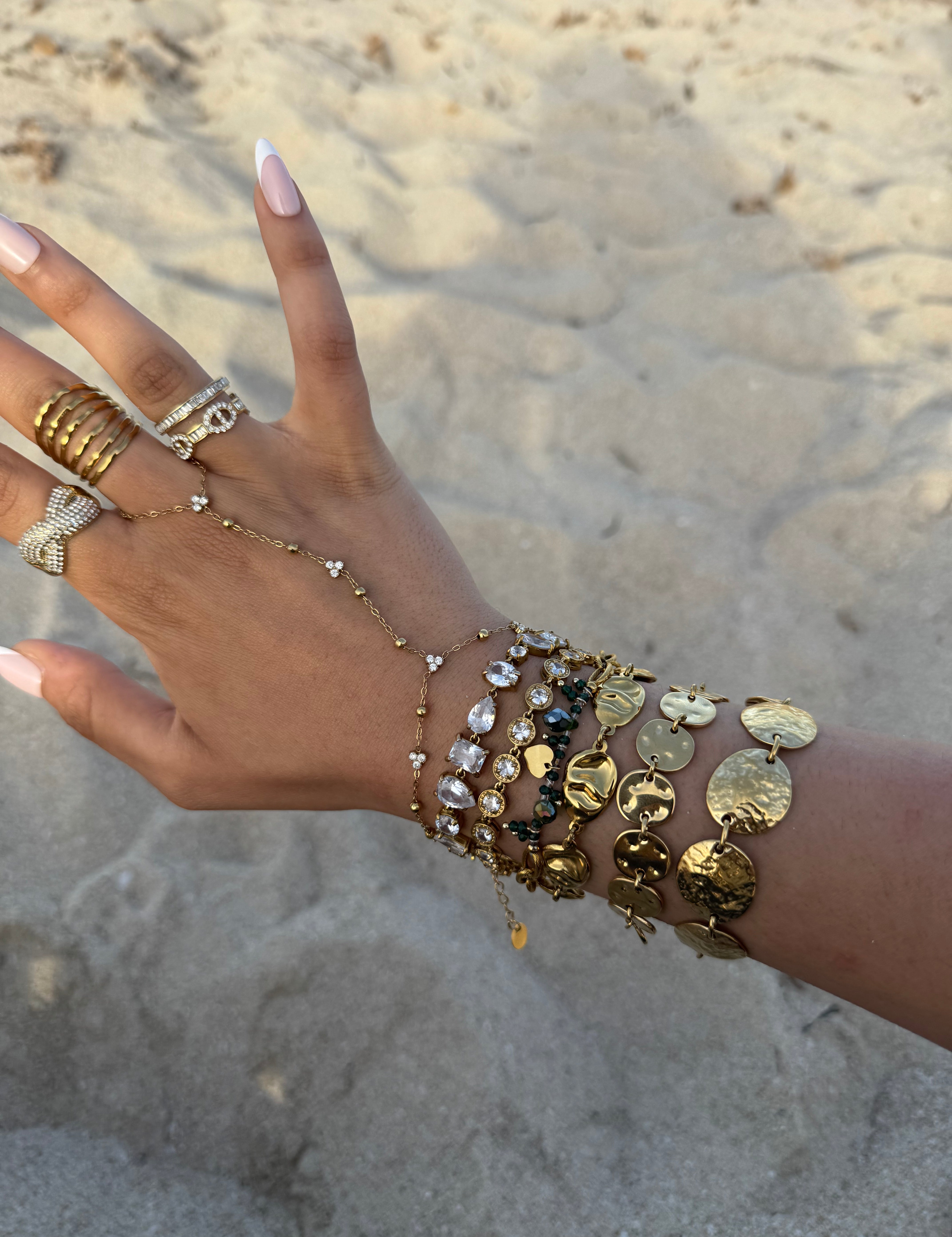 Bracelet Yasmine doré porté en accumulation au poignet, sur le sable - Ordiajade