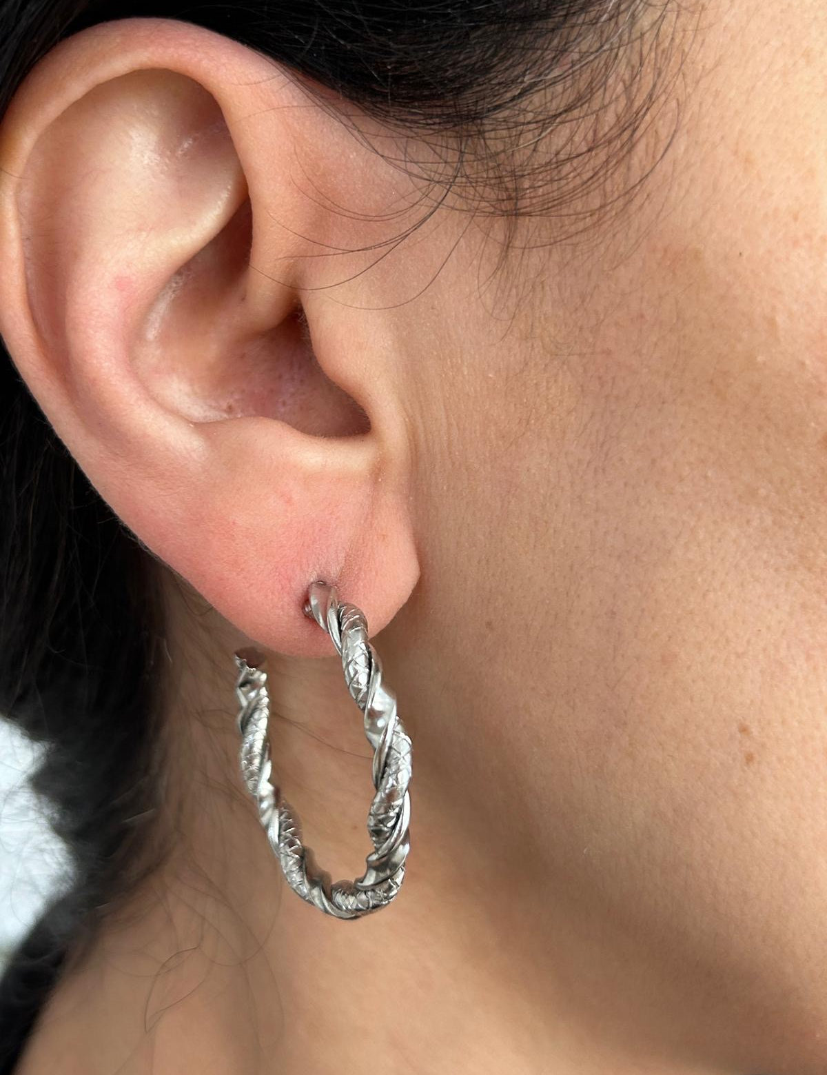 Boucles Mania, grandes créoles torsadées argentées portées à l'oreille - Ordiajade