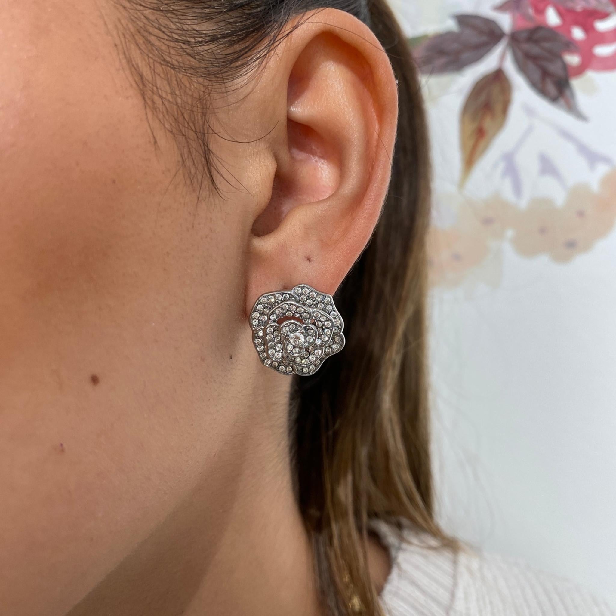 Boucles Rosie argentées en forme de fleur pavée de strass, portées à l'oreille - Ordiajade