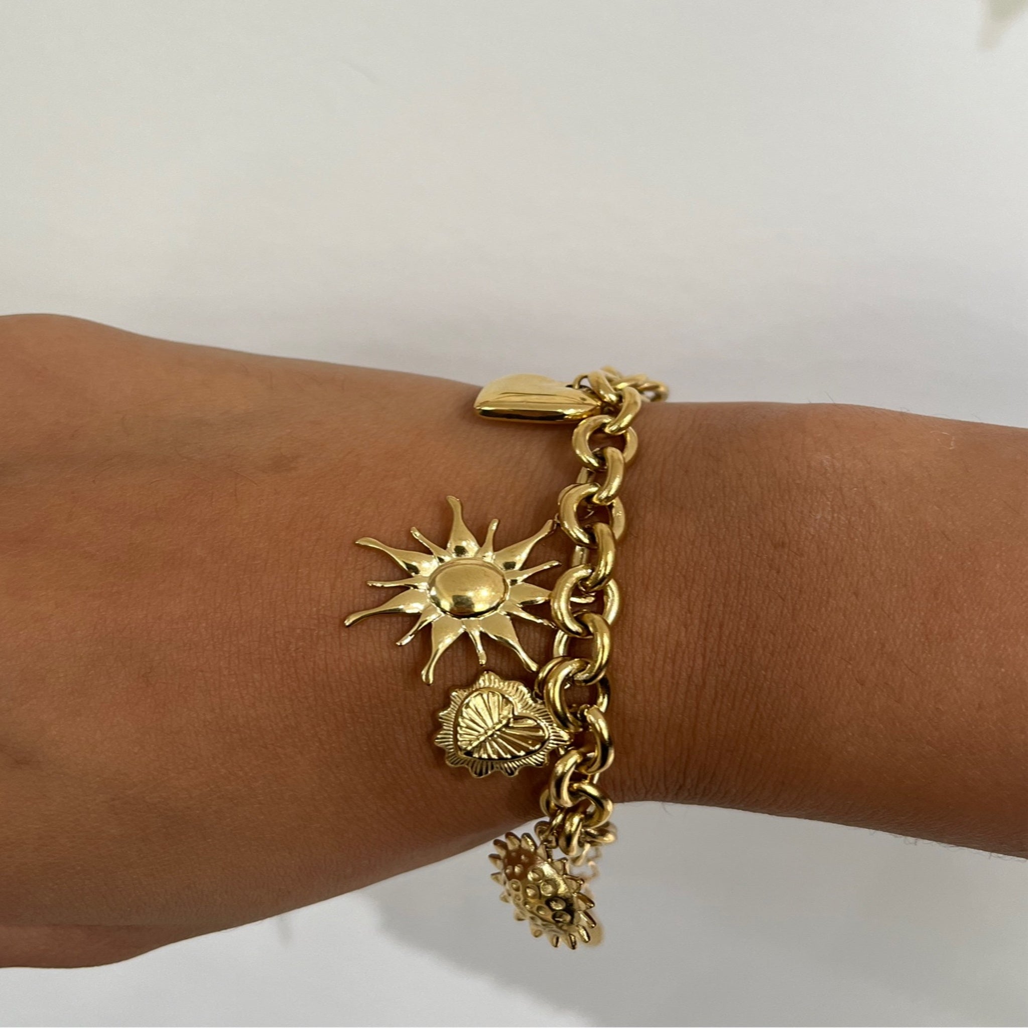 Bracelet Solaire doré à breloques soleils porté au poignet - Ordiajade