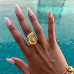 Bague Calypso dorée motif coquillage portée près de l'eau - Ordiajade