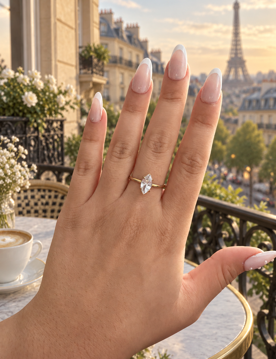 Bague Clery dorée à pierre navette portée à la main sur un balcon parisien face à la tour Eiffel - Ordiajade