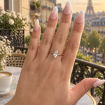 Bague Clery dorée à pierre navette portée à la main sur un balcon parisien face à la tour Eiffel - Ordiajade