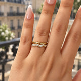 Bague Jadore ondulée dorée et pavée portée à l'annulaire, balcon parisien en arrière-plan - Ordiajade