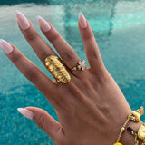 Bague Mao en acier inoxydable doré large et striée portée au doigt au bord de la piscine - Ordiajade