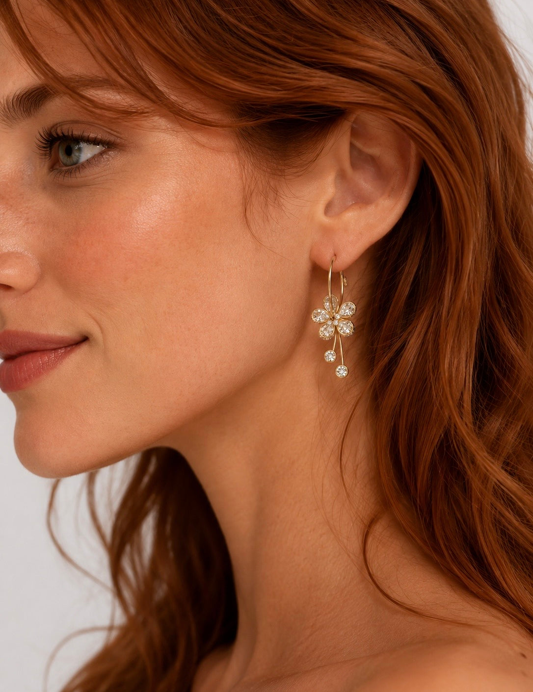 Boucles d'oreilles Fleurs dorées à strass portées par une femme, style élégant Ordiajade
