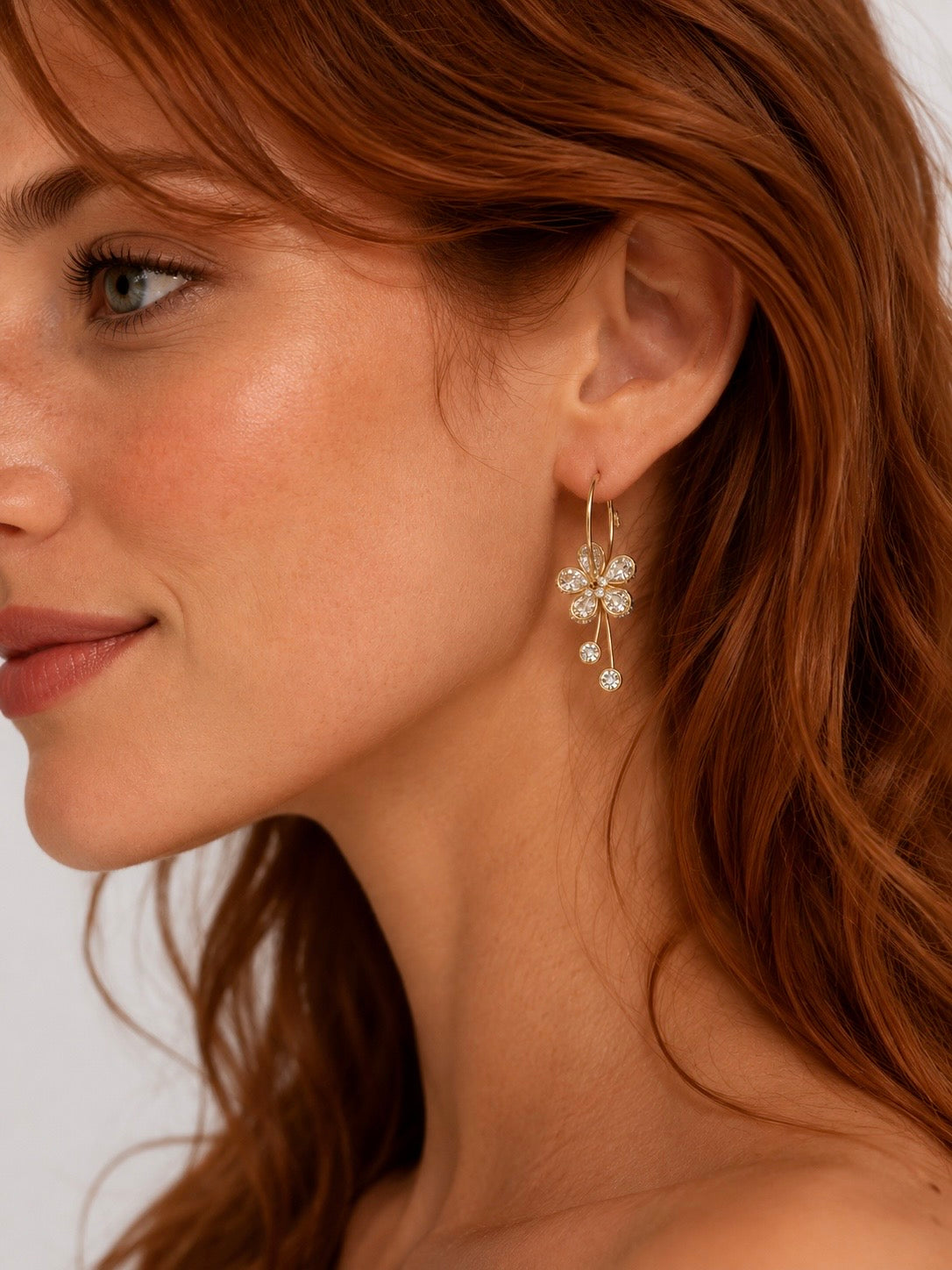 Boucles d'oreilles Fleurs dorées à strass portées par une femme, style élégant Ordiajade