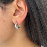 Gros plan des boucles d'oreilles créoles Juliette argentées en acier inoxydable avec cristaux portées à l'oreille - Ordiajade