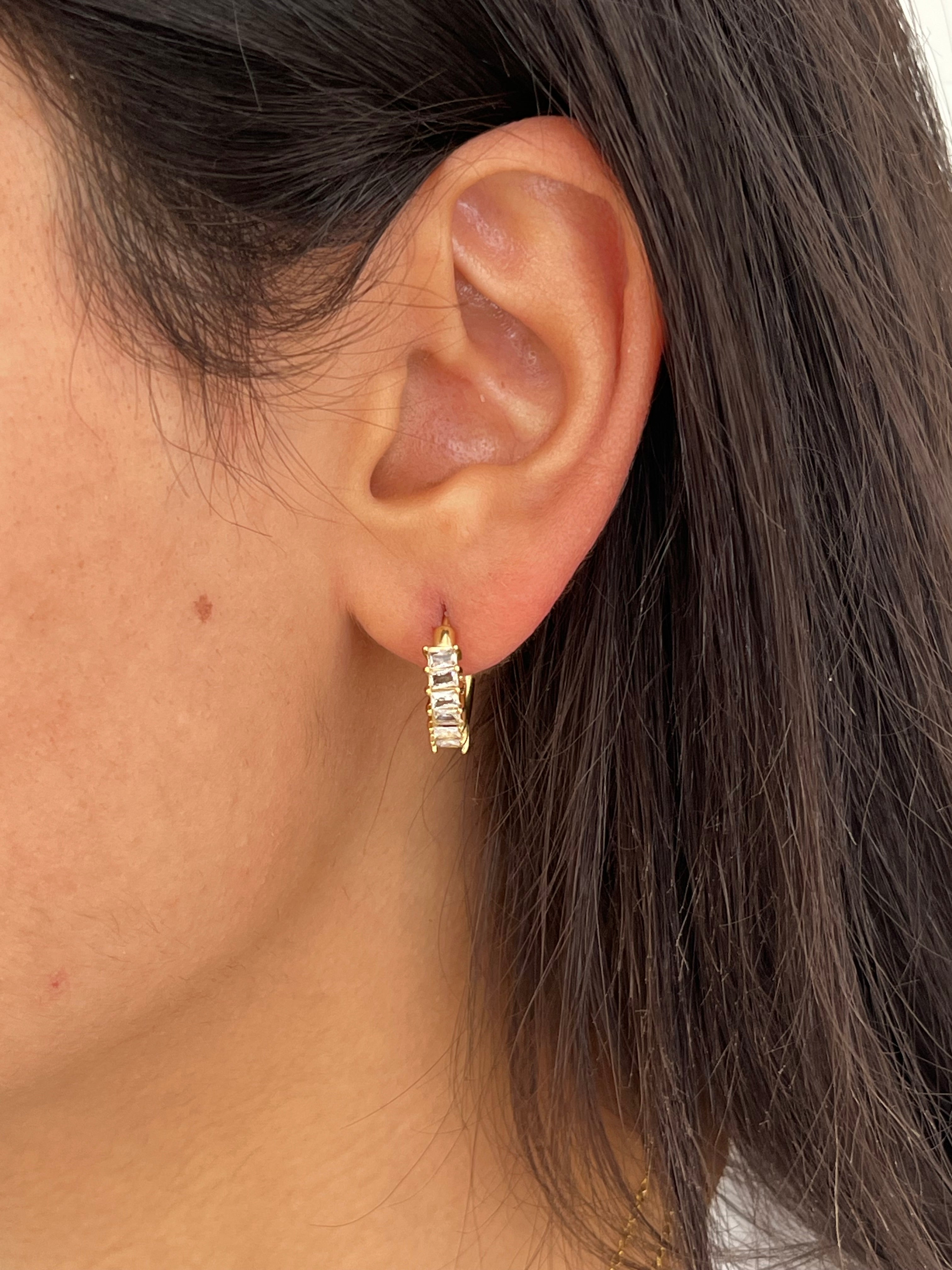 Gros plan des boucles d'oreilles créoles Juliette dorées avec cristaux baguette en acier inoxydable portées à l'oreille - Ordiajade