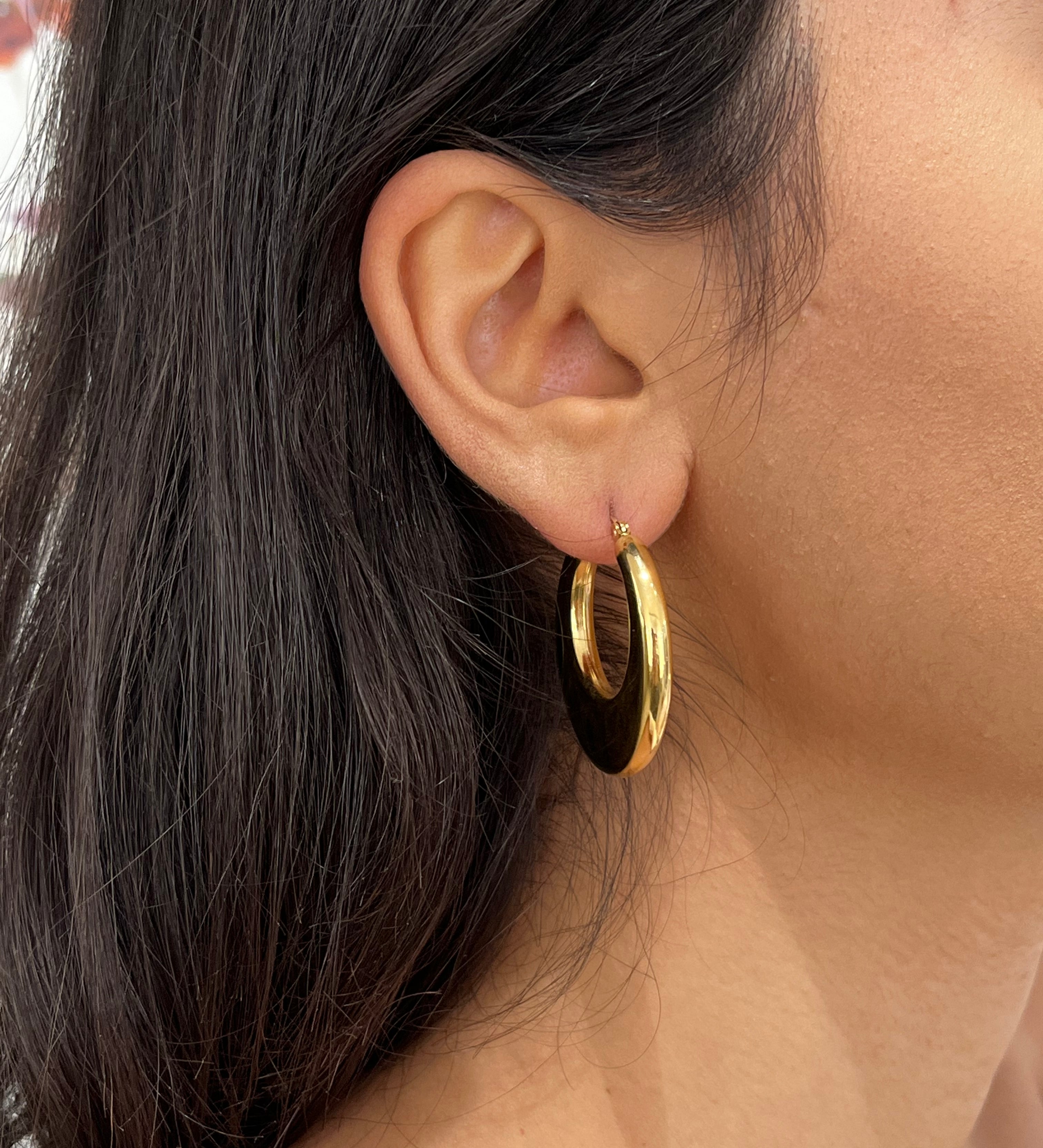 Gros plan de la boucle d'oreille créole bombée Kory dorée en acier inoxydable portée au lobe - Ordiajade
