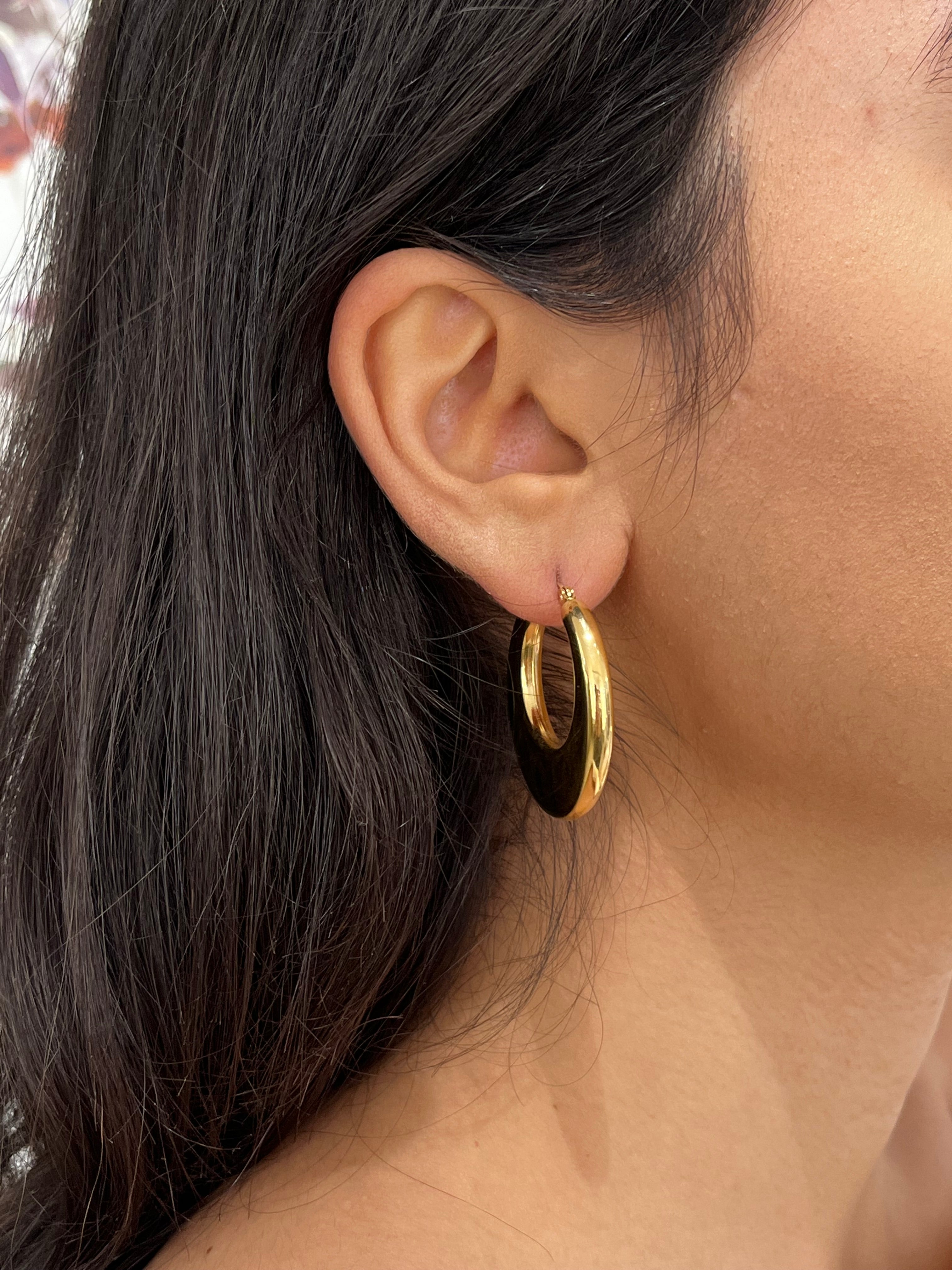 Gros plan de la boucle d'oreille créole bombée Kory dorée en acier inoxydable portée au lobe - Ordiajade
