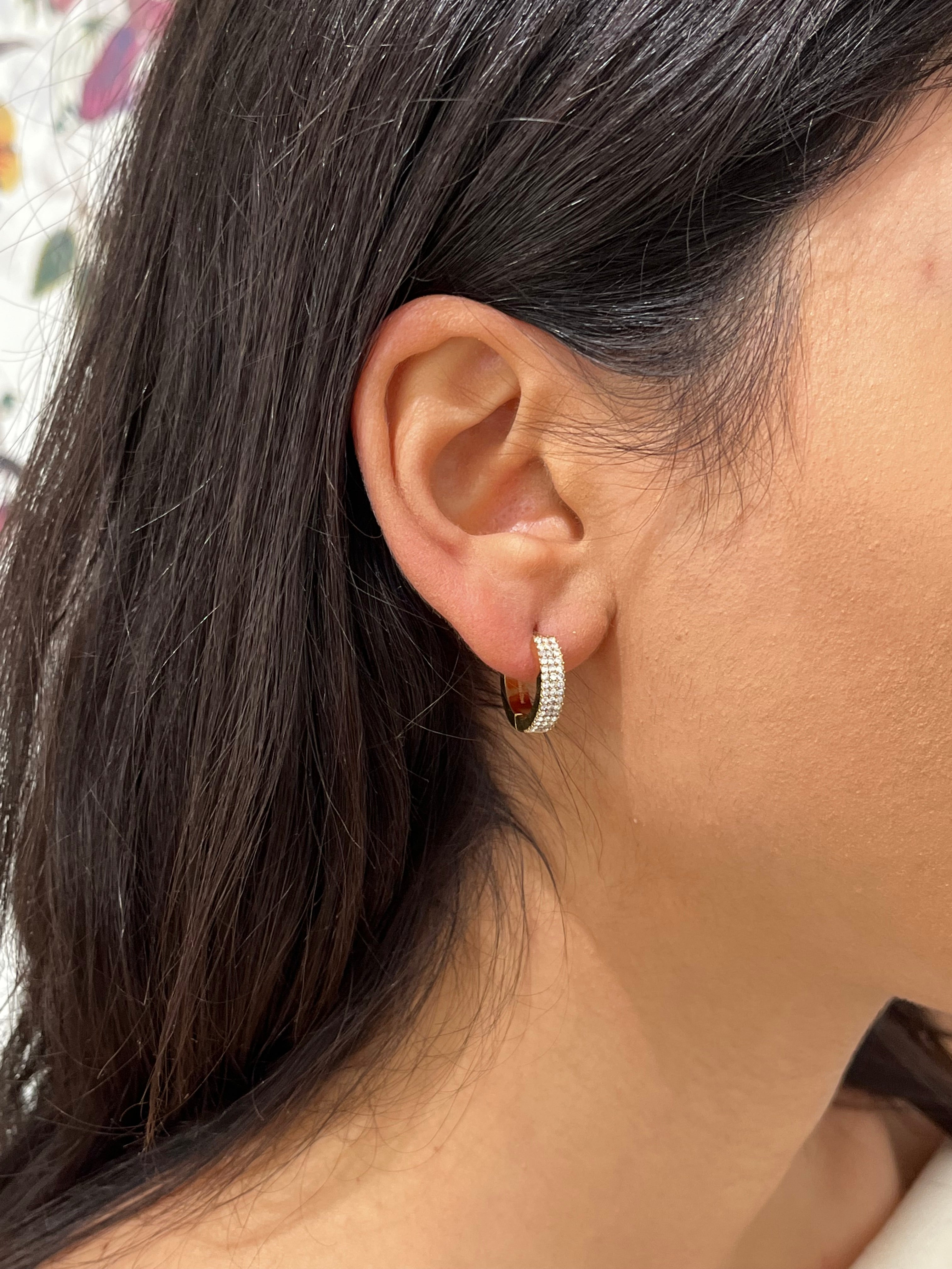 Gros plan de la boucle d'oreille créole huggie Same dorée pavée de strass portée au lobe - Ordiajade
