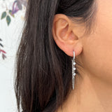 Gros plan des boucles d'oreilles Yamina argentées en acier inoxydable avec cristaux - Ordiajade