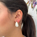 Boucles d'oreilles Horia blanches en forme de goutte portées de profil.